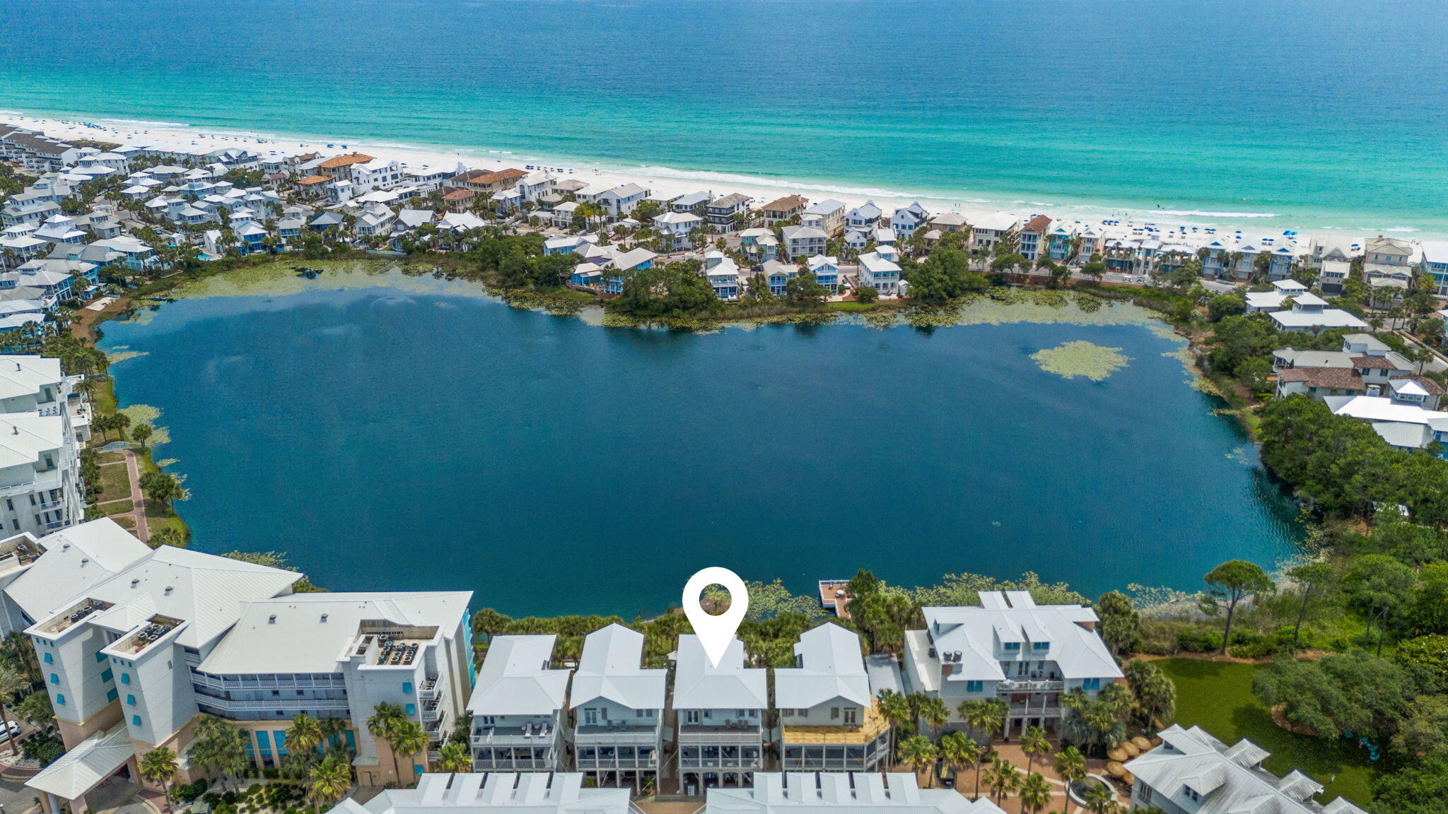 Welcome to 106 Carillon Market Street, a stand alone 2,250 sq ft town home with five spacious decks, a total of 1,100 sq ft of outdoor living space, with stunning views of the 13-acre lake known as Lake Carillon and stunning views of the Gulf. Designed for comfortable living and easy entertaining, this stand alone home features three spacious bedrooms and three full bathrooms. Going upstairs, the distressed white ship lap leads to the 2nd floor, where you will enjoy the main gathering space with an abundance of large windows and 10 ft ceilings throughout. The light-filled open floor plan flows from the kitchen, dining, and living areas to an expansive 10x20 sq ft covered porch overlooking the lake, an ideal place to unwind after a day at the beach. The fully renovated kitchen offers upgraded finishes, quartz countertops, ample new cabinetry, and a pantry. On the first floor, a private guest bedroom and full bathroom create a peaceful retreat, along with a generous 10x30 sq ft covered deck off the kitchen and guest room. Upstairs, you'll find two oversized bedroom suites, including the large primary suite. Each bedroom upstairs offers a large private bathroom with double sinks, a soaking tub, and a separate shower, providing plenty of space. The primary suite also features a 10x20 Trex sun deck overlooking the lake with Gulf views. Enjoy the ocean breeze across the lake while taking in the scenery. There is an exterior shed that provides convenient storage for all your beach gear. This furnished home offers an exceptional location with convenient beach access and NO customary use concerns. The Carillon Community features private beach access through eight walkovers and nearly a mile of uncrowded white-sand shoreline. Residents also enjoy three swimming pools, one beachfront and two others that are heated in the off-season. Along with two pickle ball courts, a tennis court, basketball court, playground, and green space. The charming Carillon Town Center includes two dining options, a coffee and wine shop, a gym, a Pilates studio, and a general store. Whether you're looking for a primary residence, second home, or investment property, this beautifully furnished home offers the perfect combination of space, style, and location. Schedule your private showing today; the Realtor office is located on-site in the community.