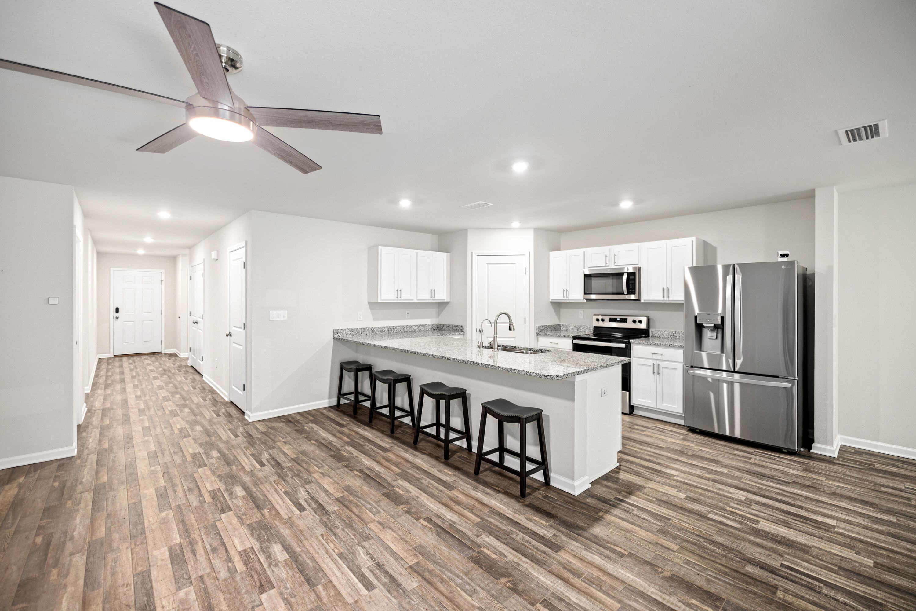 Florida is calling with community bay access, a large community pool, and nature trails right at your back door, located in the desirable RiverWalk Community in Freeport. This single-story residence offers four bedrooms, two bathrooms, and a two-car garage, combining modern finishes with comfortable everyday living.
Inside, you'll find an open-concept layout connecting the kitchen, dining, and living areas, creating a bright and inviting space perfect for entertaining. The kitchen features granite countertops, stainless steel appliances, ample cabinet space, and an LG refrigerator that conveys with the home.
The spacious primary suite includes a walk-in closet and an en-suite bathroom with a double vanity, oversized shower, and additional storage. Luxury vinyl plank flooring runs throughout the main living areas, while the bedrooms are comfortably carpeted.
Step outside to a covered back patio overlooking peaceful wooded views, offering both privacy and a relaxing outdoor setting. The home also includes numerous upgrades and smart-home features, including an LG washer and dryer, smart light and fan switches, smart doorbell and door lock, exterior security cameras, TV wall mounts, patio TV, LED color-changing eave lighting, hurricane storm panels, and a lawn sprinkler system with a yard pump.
RiverWalk residents enjoy access to a community waterfront dock and convenient proximity to shopping, dining, and the white-sand beaches of 30A.