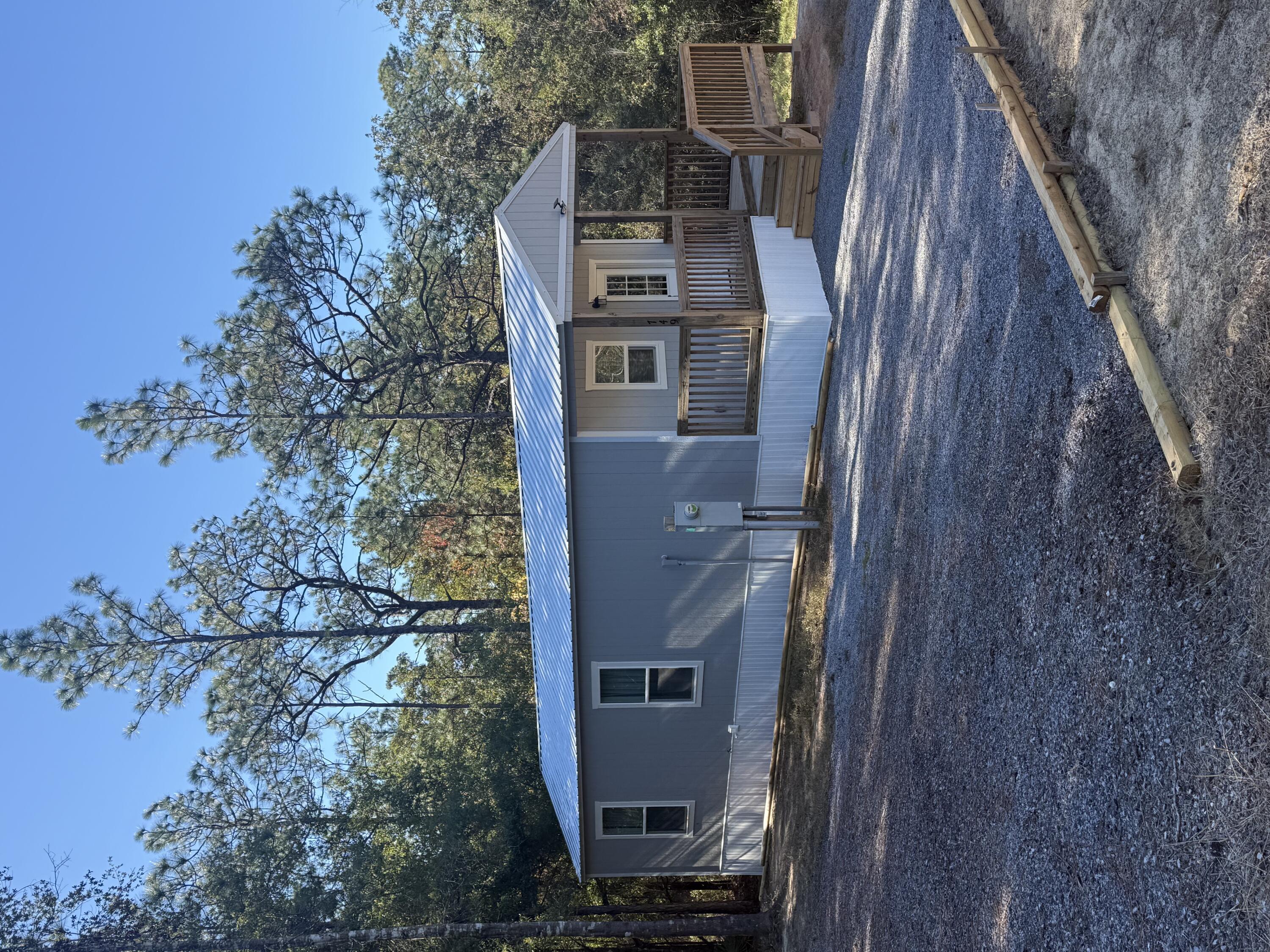 NEW PRICE! Enjoy simple living in this charming tiny home featuring two bedrooms, one bath and an energy efficient mini split system for year-round comfort. Relax on the spacious front porch overlooking the .43-acre lot, outdoor entertaining with a creek at the back of the property. Perfect for first time home buyers, downsizers, anyone looking for a cozy, low maintenance lifestyle or even just an investment.