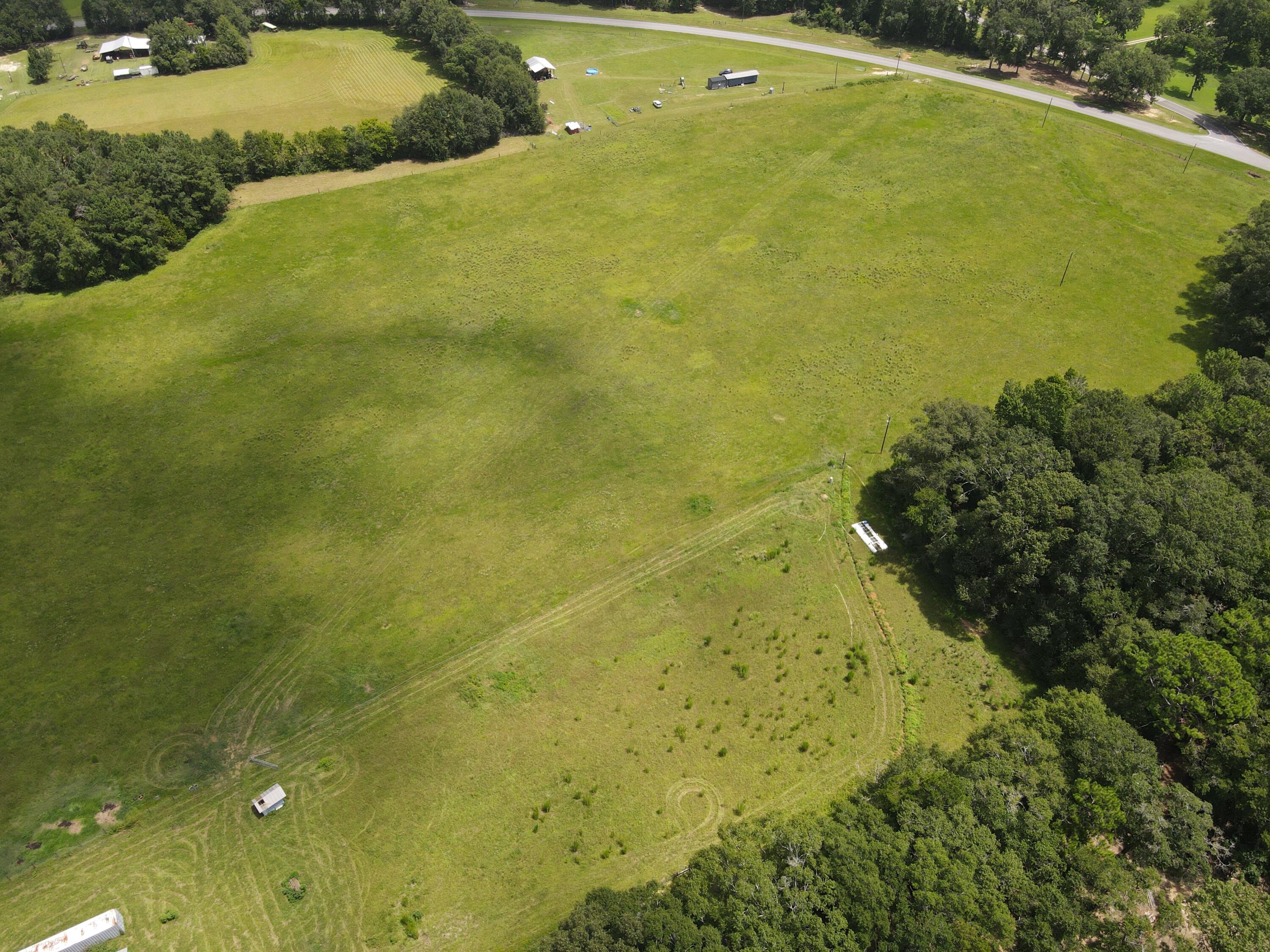 59± Acres on Paved Hwy 181 E, Walton County -- Hardwood Timber & Pasture, Pole Barn

This 59± acre tract in Walton County, Florida offers a working mix of hardwood timber and open pasture, fronting paved County Highway 181 E. Roughly two-thirds of the property -- approximately 39± acres -- is wooded in mostly hardwood timber, giving the land established tree cover, natural windbreaks, and habitat suited to wildlife and hunting. The remaining acreage, roughly 20± acres, is open pasture, currently cross-fenced in sections and suitable for grazing, hay production, or continued agricultural use.

A pole barn is already in place on the property, offering covered storage or equipment shelter without the need for new construction. The pasture areas show signs of active management, with mowed and maintained sections, existing perimeter and cross-fencing, and clear delineation between the open ground and the tree line. The wooded portion transitions gradually into the pasture, with a mix of mature hardwoods and pine visible throughout, along with some areas of sandy, exposed soil consistent with natural drainage patterns in the timber.

Additional site improvements include outbuildings and small storage structures scattered near the pasture edge, along with utility access (power poles) already run to the property line. The land's topography is gently rolling, typical of the Florida Panhandle interior.  Make an appointment today to see this well blended property.