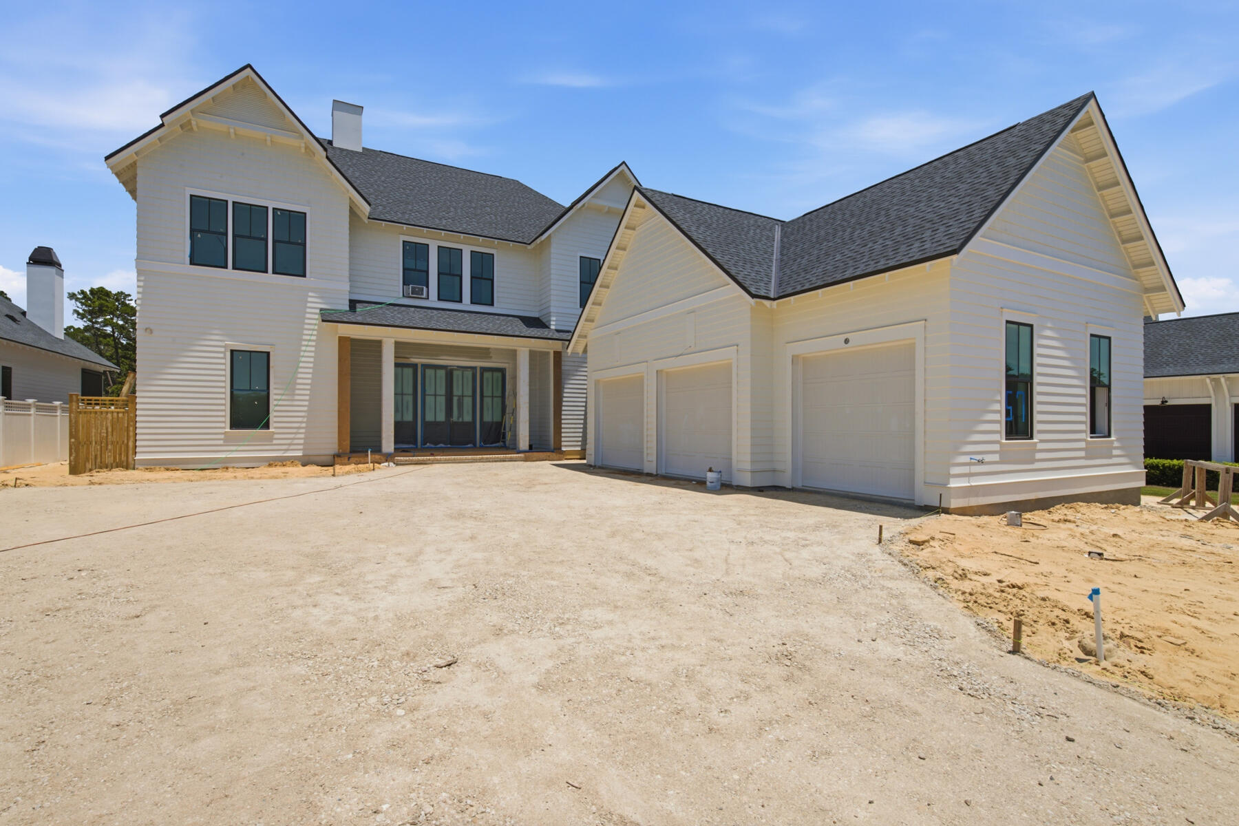 This custom home in Powell Landing West at Watersound Origins offers 4,460 square feet, 5 bedrooms, 6.5 bathrooms, and a 2-car garage with dedicated golf cart bay. Located on a 140' deep homesite with a wooded backdrop and just steps from the community dock at Lake Powell, the home is estimated for completion end of Sept '26.

The exterior combines Premium Nichiha lap and shake siding, premium plantation shutters, 9' exterior doors, and an expanded window package. Inside, the layout opens to a vaulted living room with exposed wood beams, Venetian plaster wood-burning fireplace, and a 16' sliding glass door connecting to the rear porch and pool area.

The kitchen is centered between the living and dining spaces and features a 10.5' marble island, upgraded cabinetry with soft-close doors and drawers, walk-in pantry, and separate butler's pantry with sink, beverage refrigeration, ice maker, and additional Sub-Zero refrigeration. The appliance package includes dual 36'' Sub-Zero refrigerators, a 48'' dual fuel Wolf range, vent hood, microwave drawer, and Cove dishwasher.

The primary suite is privately positioned at the rear of the home and includes a freestanding tub, walk-in shower with bench, upgraded Brizo fixtures, and a large walk-in closet with custom shelving. All secondary bedrooms include ensuite bathrooms and walk-in closets. The second floor features additional guest accommodations and a balcony overlooking the pool area. Ceiling heights of 12' on the first floor and 10' on the second floor maintain consistent scale throughout.

Outdoor living includes a 10' x 30' saltwater pool and spa with upgraded mosaic tile, extended paver decking, roll-down screens, summer kitchen, and exterior wood-burning fireplace with brick surround and mantel.

Additional features include Medallion wood flooring throughout, white oak solid core interior doors, crown molding across both levels, epoxy garage flooring, conditioned garage space with mini split system, dehumidifiers, two washer/dryer sets, and upgraded hardware and fixtures throughout.