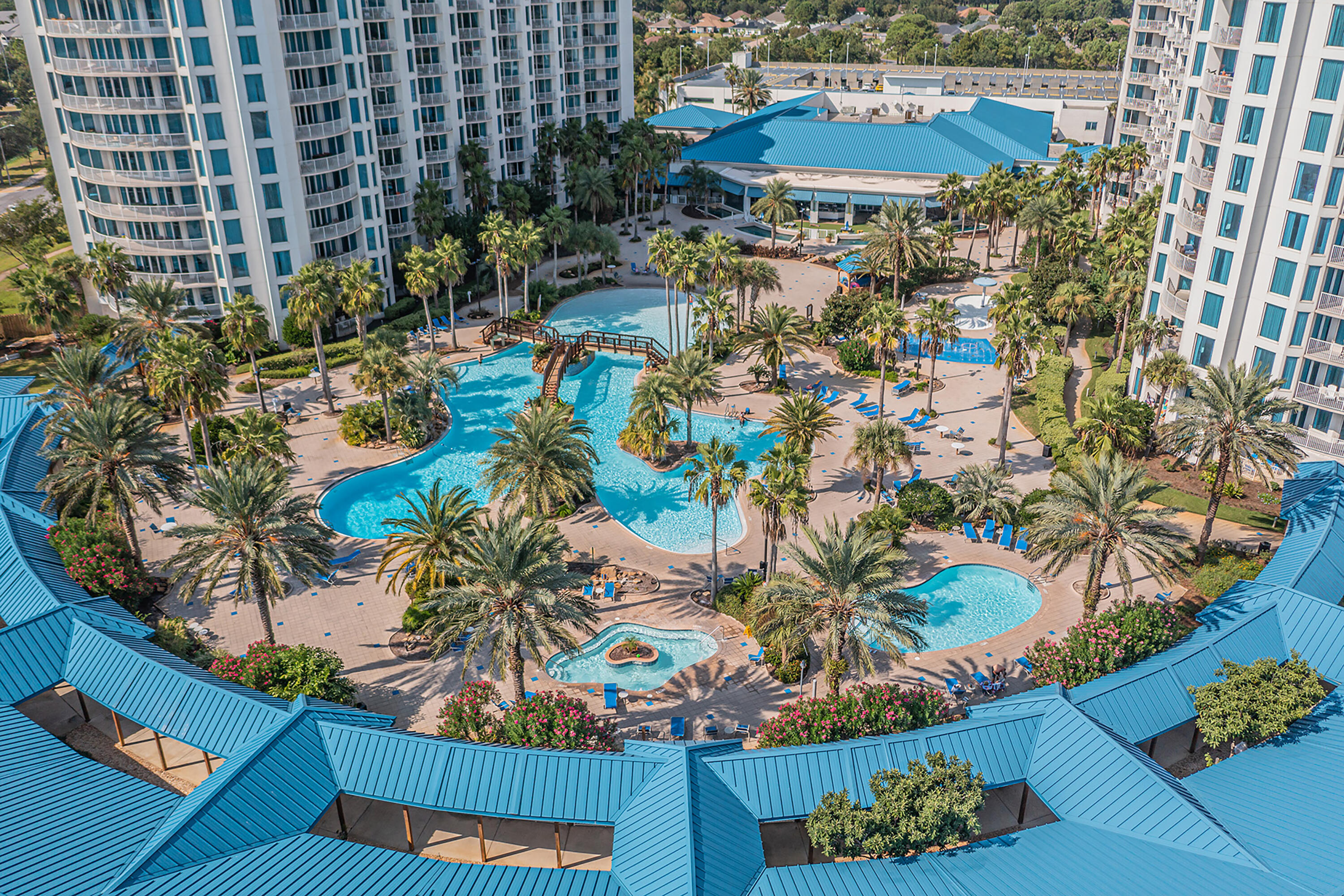 Wake up to Gulf breezes and resort living every single day. Perched on the 9th floor of one of Destin's most sought-after communities, this beautifully updated 2-bedroom, 2-bathroom turnkey condo at The Palms of Destin offers breathtaking views of the lagoon-style pool, cascading waterfalls, and a stunning peek of the Gulf of Mexico. Whether you are searching for a personal coastal retreat, a vacation home, or a short-term rental investment with tremendous income potential, this property is primed and ready to deliver. Step inside and you will immediately notice the attention to detail throughout. Fresh interior paint, luxury vinyl plank flooring, and elegant white quartz countertops create a bright, modern coastal atmosphere that appeals to buyers and guests alike. The open-concept floor plan connects the kitchen, dining, and living areas seamlessly, making the space feel both expansive and welcoming. The kitchen features sleek black appliances, ample cabinet storage, and a breakfast bar ideal for casual mornings or entertaining. Both private balconies invite you to soak in the tropical resort atmosphere and gentle Gulf breezes that make Destin living so special. The primary suite offers its own balcony access and an en-suite bath, providing a peaceful escape at the end of every day. The second bedroom has been thoughtfully designed with custom barn doors and built-in bunk beds, maximizing both functionality and rental occupancy potential.  Residents and guests enjoy access to an exceptional array of resort amenities that truly set this community apart, including three pools featuring a heated pool, a lagoon-style pool with cascading waterfalls, and a kiddie pool, along with a hot tub, fitness center, basketball courts, indoor and outdoor pickleball courts, tennis courts, a children's playground, and a barbecue grilling area. Beach lovers will appreciate the easy access to Destin's sugar-white sand beaches just across the street, with a complimentary resort shuttle to take you there and back. Nestled close to premier dining, shopping, and entertainment, this location is simply unmatched on the Emerald Coast. Do not miss your opportunity to own a piece of paradise. Schedule your private showing today and experience the Destin lifestyle for yourself.