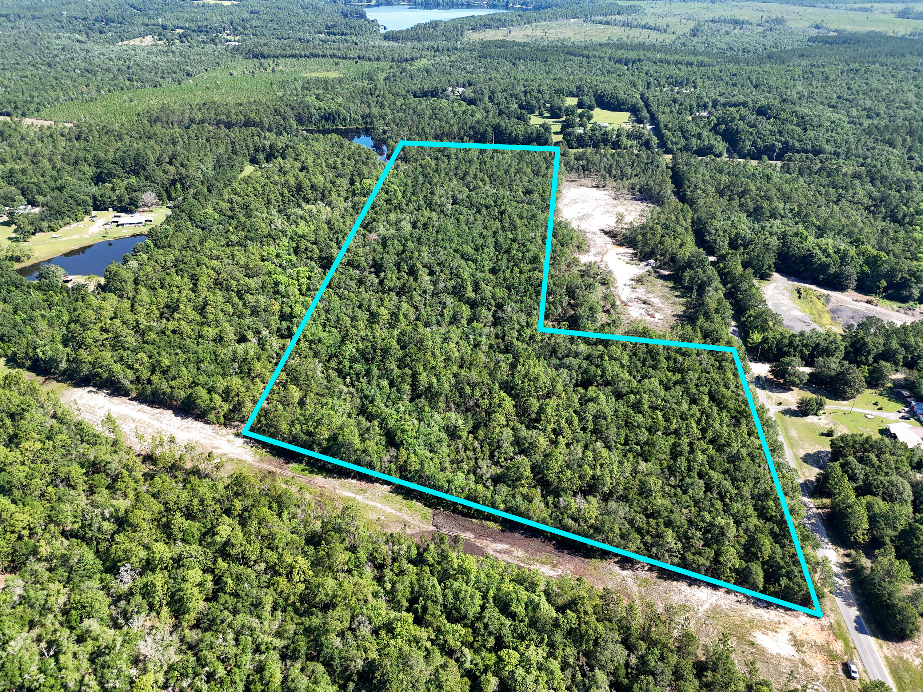 Discover this beautiful 30.64-acre wooded tract located in DeFuniak Springs, Florida.  See photos for topographic map, elevation 230 feet above sea level! Offering privacy, natural beauty, and exceptional versatility, this property is a rare chance for buyers looking for recreational land, future homesites, or a unique investment opportunity in a growing area of Walton County. Zoned Rural Village, the property allows a maximum density of up to 2 homes per acre, opening the door for potential residential development, family compound use, or multiple homesites. Rural Village zoning allows a variety of commercial uses, including a general store, feed sales, fishing camps, bait and tackle shops, RV parks or campgrounds connected to outdoor recreational uses, and riding or boarding stables. A large stocked pond sits on the northwest corner of the property, creating a peaceful setting for fishing bird watching. With mature trees throughout and plenty of room to spread out, this land offers the perfect blend of seclusion and convenience. Located just 10 minutes from the center of DeFuniak Springs and only approximately 30 minutes from the beautiful beaches of South Walton, this property provides easy access to town, shopping, dining, and the Gulf Coast while still offering the quiet, rural lifestyle so many buyers are looking for.