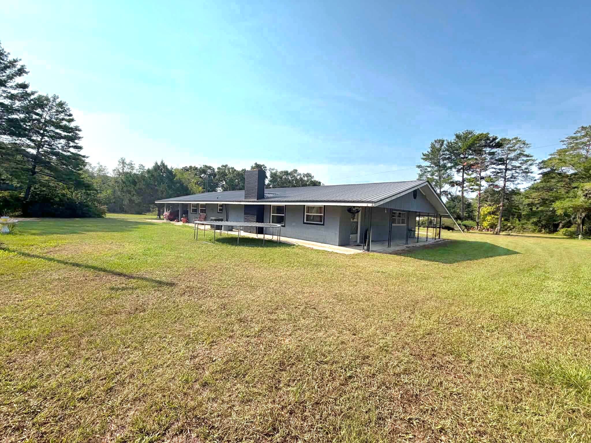 PRICED to SELL! Finding a home with mini farm in rural Red Bay is rare. Check out this large home on nearly 1.5 acres that is solid built with block construction, metal roof, and plaster walls. 3275 square feet with 4 bedrooms and 3 full baths! There is also au finished separate 800 sq ft apartment or Mother-in-law space with a large living area, bedroom, it's own carport, and a kitchenette! Has been an income producer on AirBNB Bring your animals and If you enjoy swimming, the above-ground pool is READY for that dip, jump in off the renovated deck.  Enjoy the quiet and peaceful enjoyment of country life, convenient to I-10 and just 30 minutes to the beautiful sugar white sand beaches of Panama City Beach and Santa Rosa Beach.