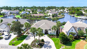 Welcome to waterfront living in the highly sought-after gated community of Bay Point! Located on a canal with direct access to St. Andrews Bay and the Gulf in just minutes, this beautifully remodeled 4-bedroom, 2.5-bath home offers the perfect blend of luxury, comfort, and coastal lifestyle. Situated at approximately 9 feet above sea level, this home has been extensively remodeled and updated throughout with new interior and exterior paint, renovated finishes down to the last ceiling fan and light fixture, granite countertops in the kitchen and all bathrooms, contemporary backsplash accents, and a beautiful gas fireplace with a modern setting. The spacious interior features soaring 10 and 12-foot ceilings with extensive crown molding, creating an open and elegant feel throughout the home. Designed for both comfort and peace of mind, the home includes a built-in 10,000-watt generator capable of powering most of the home during outages, a new 17 SEER 5-ton Rheem HVAC system installed in 2025, new water heater in 2024, and a 30-year architectural roof installed in 2019. Additional features include a designer shower in the guest bath, air-conditioned garage, new Whirlpool refrigerator in the kitchen, and an additional GE side-by-side refrigerator in the garage. Step outside into your own tropical paradise featuring lush updated landscaping, automatic irrigation system, heated pool with new 2024 heat pump pool heater, spacious pool lanai, and canal frontage complete with a boat lift equipped with remote control operation. The Bay Point canal system provides easy boating access to St. Andrews Bay and the Gulf within minutes. Bay Point offers gated security along with incredible amenities including a full-service marina, restaurant, golf, tennis, and a true coastal lifestyle just minutes from everything Panama City Beach has to offer. This is more than just a home -- it's a lifestyle.