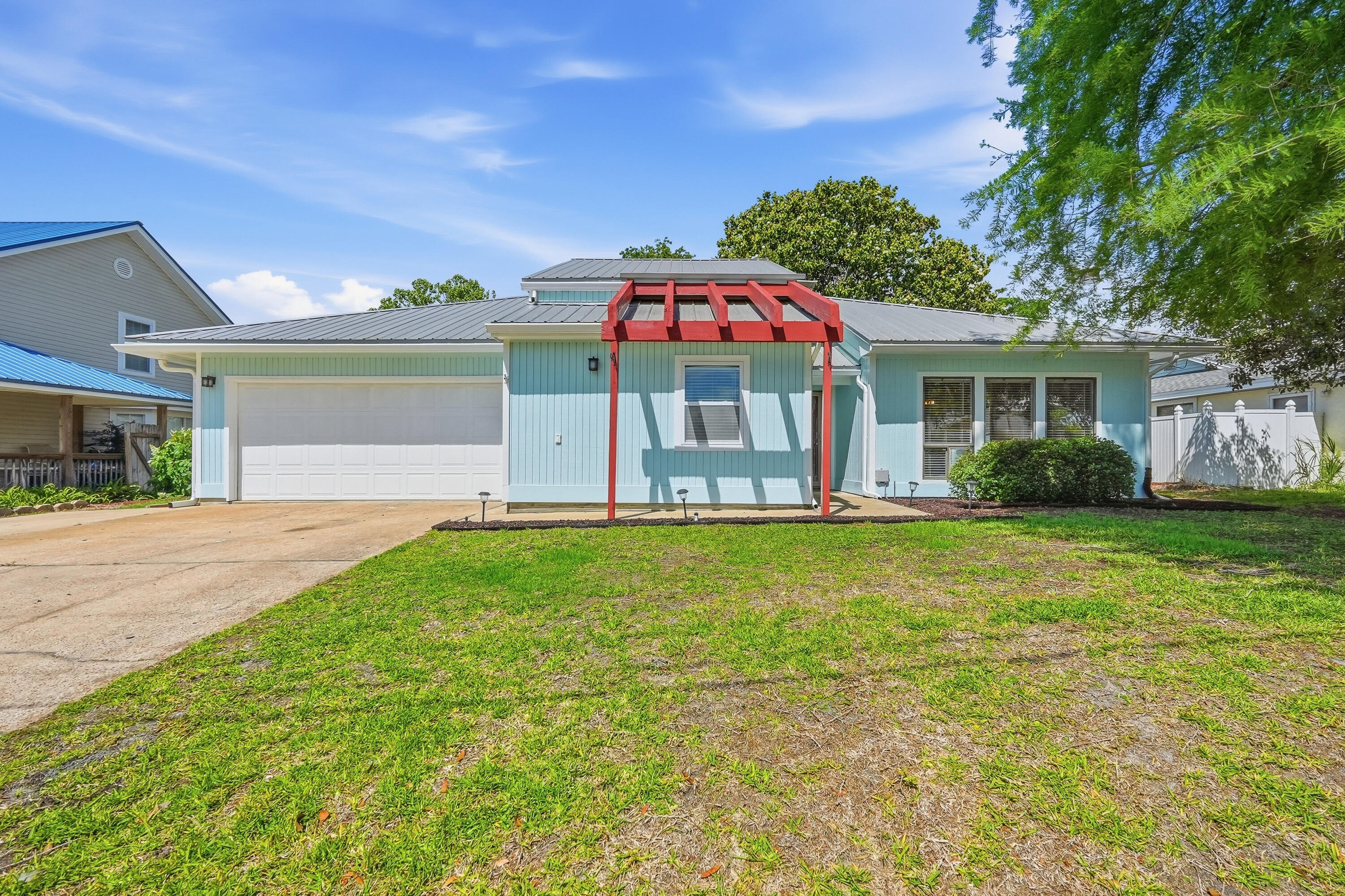 Well-maintained ranch-style home located in the heart of Destin, offering an open-concept layout with vaulted ceilings, exposed beams, and skylights that bring in natural light throughout the main living space. The living room features a stone-accented wood-burning fireplace, creating a warm and inviting focal point.

The kitchen includes stainless steel appliances and flows seamlessly into the main living and dining areas. The primary suite offers generous space, dual closets, and an updated bathroom with a tiled walk-in shower and cultured marble countertops. Laminate flooring runs throughout the main living areas.

Additional features include a screened-in porch and a spacious yard, along with added parking suitable for multiple vehicles or recreational use. Conveniently located near shopping, dining, local schools, and the Destin Harbor, this home offers a great opportunity in a central location.