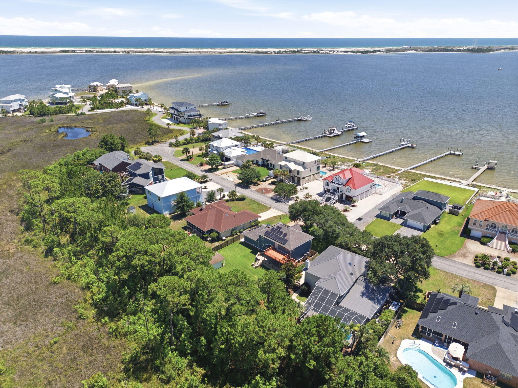 Emerald Pointe | Coastal Luxury Reimagined

Welcome to Emerald Pointe, one of the Emerald Coast's most desirable waterfront communities, where coastal living meets everyday convenience. Known for its abundance of water-view homes, neighborhood beach access, and breathtaking views of the Santa Rosa Sound, this community offers the lifestyle so many dream about.

Completely reimagined from the inside out, this stunning two-story coastal blue beauty has been professionally remodeled and reconfigured to rival brand-new construction. Every detail was thoughtfully designed with quality, longevity, and modern coastal elegance in mind.

From the moment you arrive, you'll appreciate the meticulous landscaping, oversized backyard entertaining deck, corner storage shed, and fully fenced backyard with plenty of room to build the pool you've always wanted. Many neighboring homes already feature private pools, making this an ideal backyard retreat.

Step inside and you'll immediately notice the abundance of natural light pouring through the dramatic staircase windows while beautiful water views greet you from multiple rooms throughout the home. Step outside into the front yard and you'll even hear the relaxing sound of the nearby waves. The extensive renovation includes impact-rated windows throughout, new Hardie® siding, gutters, modern driftwood-inspired luxury vinyl plank flooring, new cabinetry, premium appliances, a gas range, tankless gas water heater, new PEX plumbing, upgraded electrical, designer lighting, modern ceiling fans, updated hardware, and beautifully redesigned bathrooms. Custom closet systems replace traditional wire shelving throughout much of the home, offering both style and functionality.

Designed for today's lifestyle, this spacious floor plan offers 4 bedrooms, an oversized family room overlooking the breakfast area and designer kitchen, an expansive walk-in laundry room, dedicated office, plus an additional flex room with water views--perfect for a second office, homeschool space, children's playroom, reading nook, or fitness area.

One of the greatest advantages of this home is the peace of mind that comes with such an extensive renovation. During ownership, the sellers discovered evidence of prior termite damage from years before they purchased the property. Rather than simply making cosmetic repairs, they made the decision to professionally rebuild the affected areas correctly using licensed contractors and high-quality materials throughout. The result is a home that offers the character of an established neighborhood with the confidence and quality of modern construction.

Living in Emerald Point means enjoying kayaking, paddleboarding, fishing, and waterfront sunsets just steps from your neighborhood--without battling Highway 98 traffic to reach the water. The community offers spectacular views of the Navarre Bridge and surrounding waterfront while remaining only one minute from East Navarre, less than 10 minutes to Navarre Beach, and under 30 minutes to Destin. Hurlburt Field, Eglin AFB, schools, shopping, restaurants, and grocery stores are all conveniently nearby, making this location ideal for both military and civilian buyers.

With nearly every major system upgraded, buyers may also benefit from more favorable insurance opportunities compared to homes with older components. Combined with the move-in-ready condition, professional cleaning, and immediate availability for closing, this is an exceptional opportunity to own a beautifully renovated coastal home in one of the area's most sought-after waterfront communities.

If you've been searching for water views, quality craftsmanship, and a home that truly feels like new construction--without the new construction price tag--this Emerald Pointe masterpiece is one you simply cannot miss.