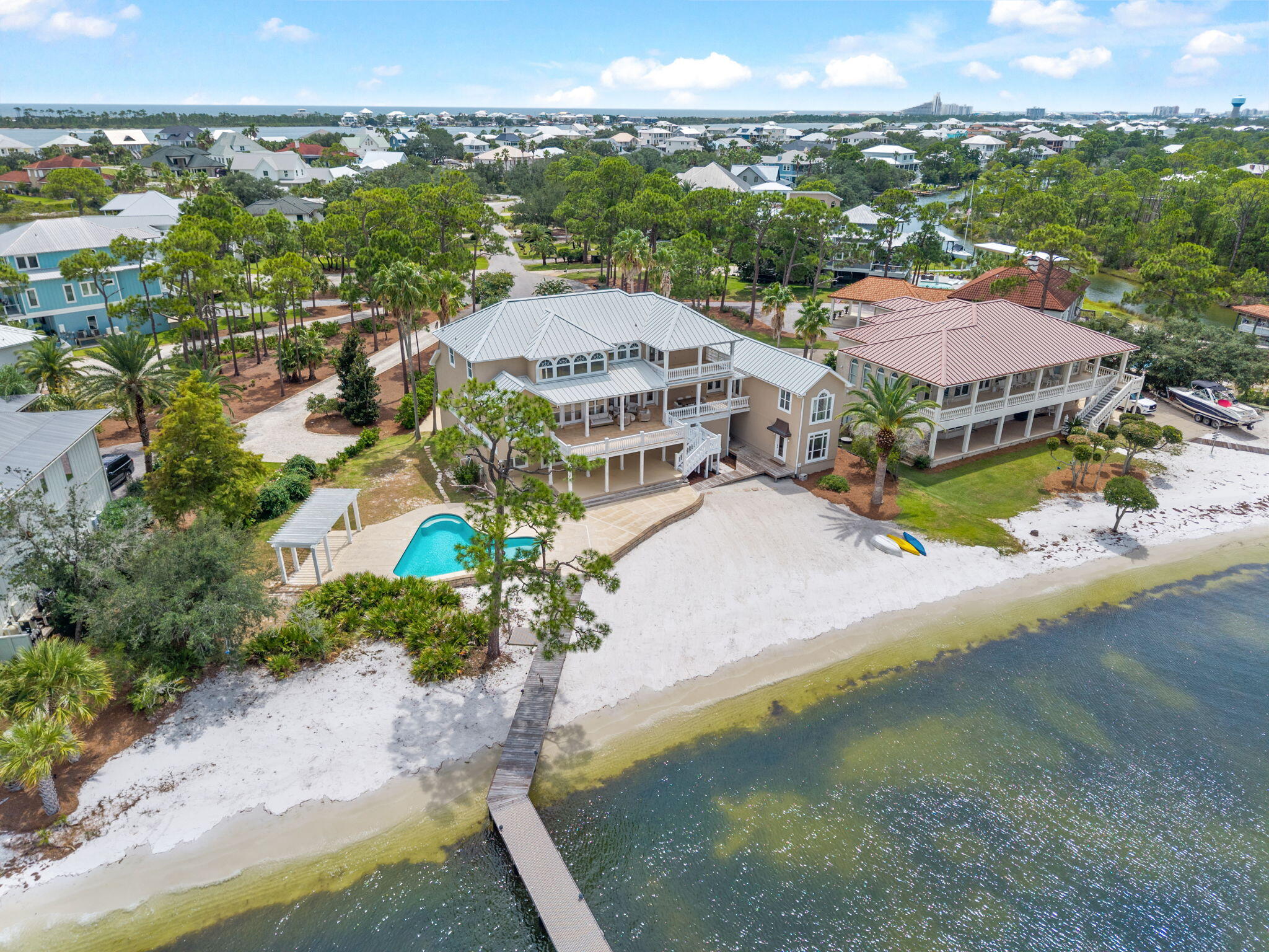 Pavers and lush landscaping welcome you to this exceptional waterfront residence overlooking Bayou St. John, offering over 6,000 square feet of living space and nearly 200 feet of waterfront with a private sandy beach. Breathtaking water views are captured throughout the home, while multiple balconies and expansive outdoor living areas provide an ideal setting for entertaining and enjoying the waterfront lifestyle. At the heart of the home is a brand-new luxury kitchen, beautifully redesigned with custom cabinetry, new countertops, generous bar seating, and premium Sub-Zero and Wolf appliances. Additional updates include new lighting and wood flooring throughout the main living areas. An elevator provides convenient access to all floors. The ground level features oversized garages, workspace, abundant storage, flexible bonus rooms, and a private mother-in-law suite complete with its own living area and full kitchenette. Outdoors, enjoy a waterfront saltwater pool, outdoor shower, and outdoor kitchen just off the main balcony. The recently updated dock features reinforced pilings, flow-through decking, and two lifts, including an 8,000-lb lift accommodating boats up to 17 feet and a 20,000-lb lift accommodating boats up to 32 feet. The boathouse includes storage, a fish-cleaning station, and a charging station. A durable metal roof further enhances this exceptional waterfront estate.