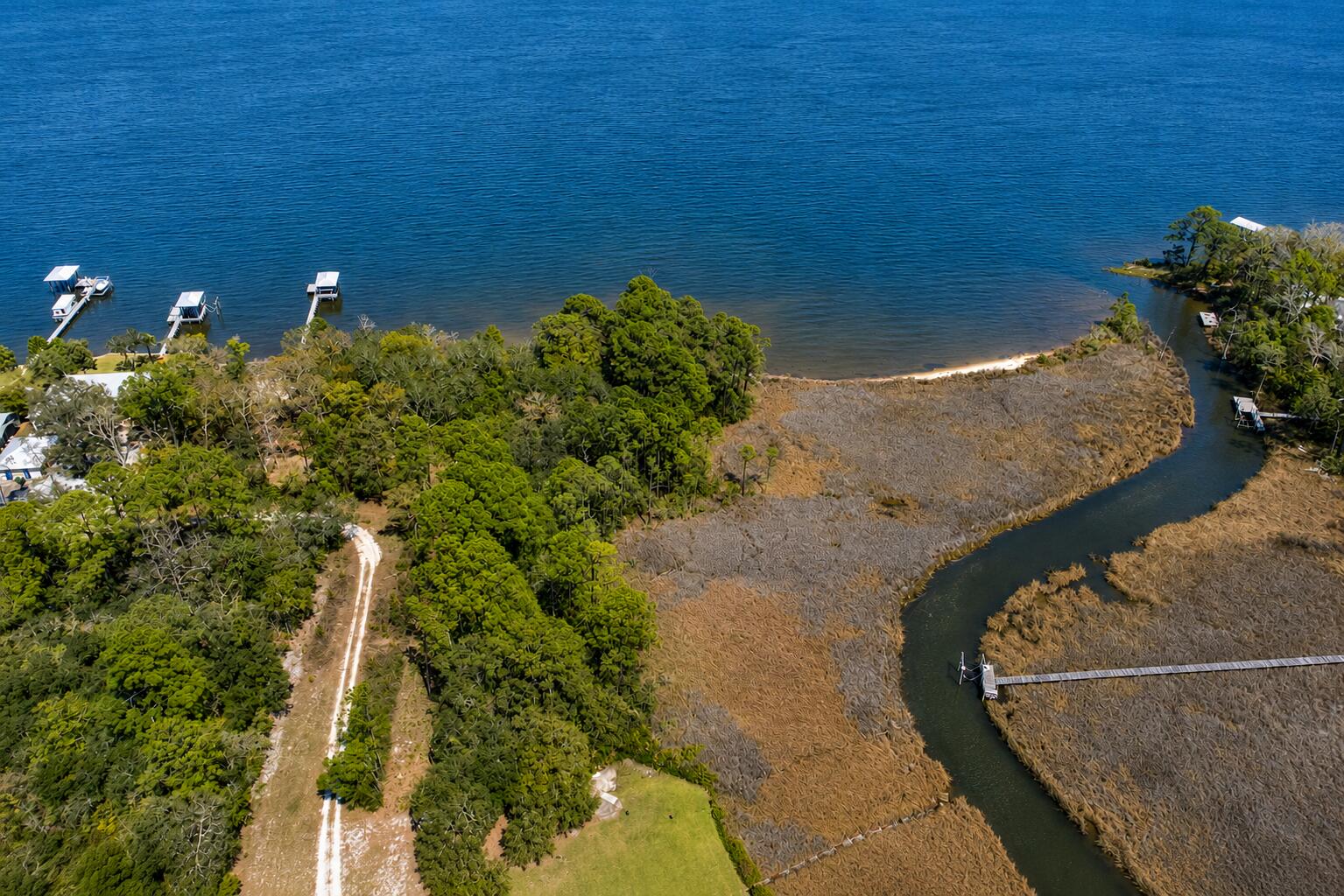 This bayou-front homesite in the quiet Santa Rosa Beach area offers a unique opportunity to create your own coastal retreat within the Rosestar Subdivision off Bay Magnolia Lane. Spanning approximately 0.44 acres (18,971sqft), the property allows for boat slips and provides direct access to boating, kayaking, fishing, and other waterfront activities on Choctawhatchee bay right from your backyard. Situated on a private road with no HOA, it offers added freedom and flexibility in design and construction while maintaining a peaceful, natural setting.