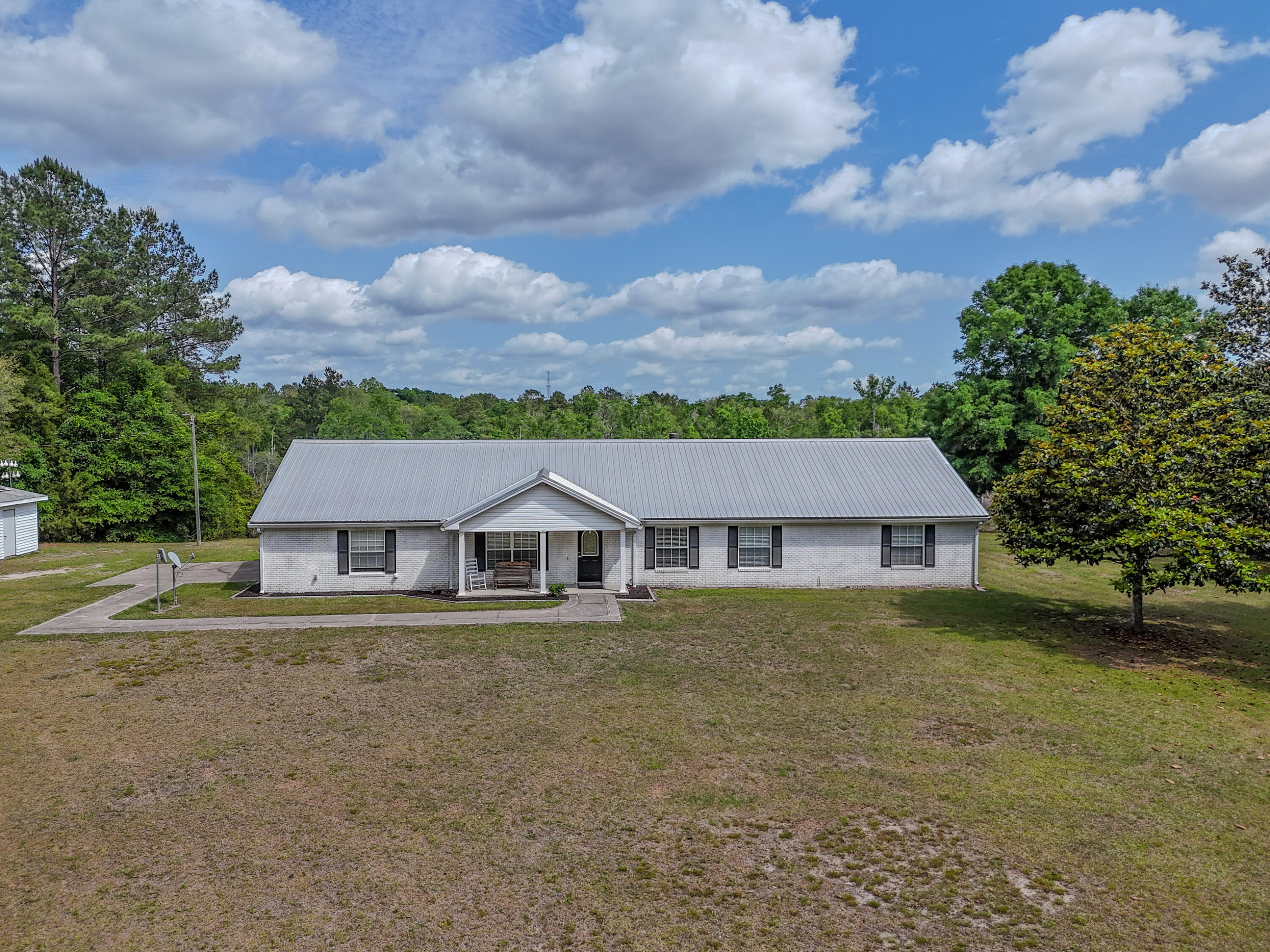 35 acres, Heated pool, Ponds, abundant wildlife, and room to breathe. This isn't just a property; it's the kind of place people dream about owning. This beautiful 4BR/3BA brick ranch offers nearly 2,000 sqft with open floor plan, tile flooring, and fireplace that makes it feel like home. Outside the possibilities are endless with stocked ponds, abundant wildlife, partially fenced land for livestock, a pole barn with 30-amp RV hookup, storage shed, detached garage complete with the well, water softener, and plenty of additional storage space. The heated pool with full enclosure makes year-round enjoyment possible, while major updates like a metal roof (2020), HVAC (2022), and whole-home sanitizer add peace of mind. Private country living with modern comfort, all within a short drive to PCB.