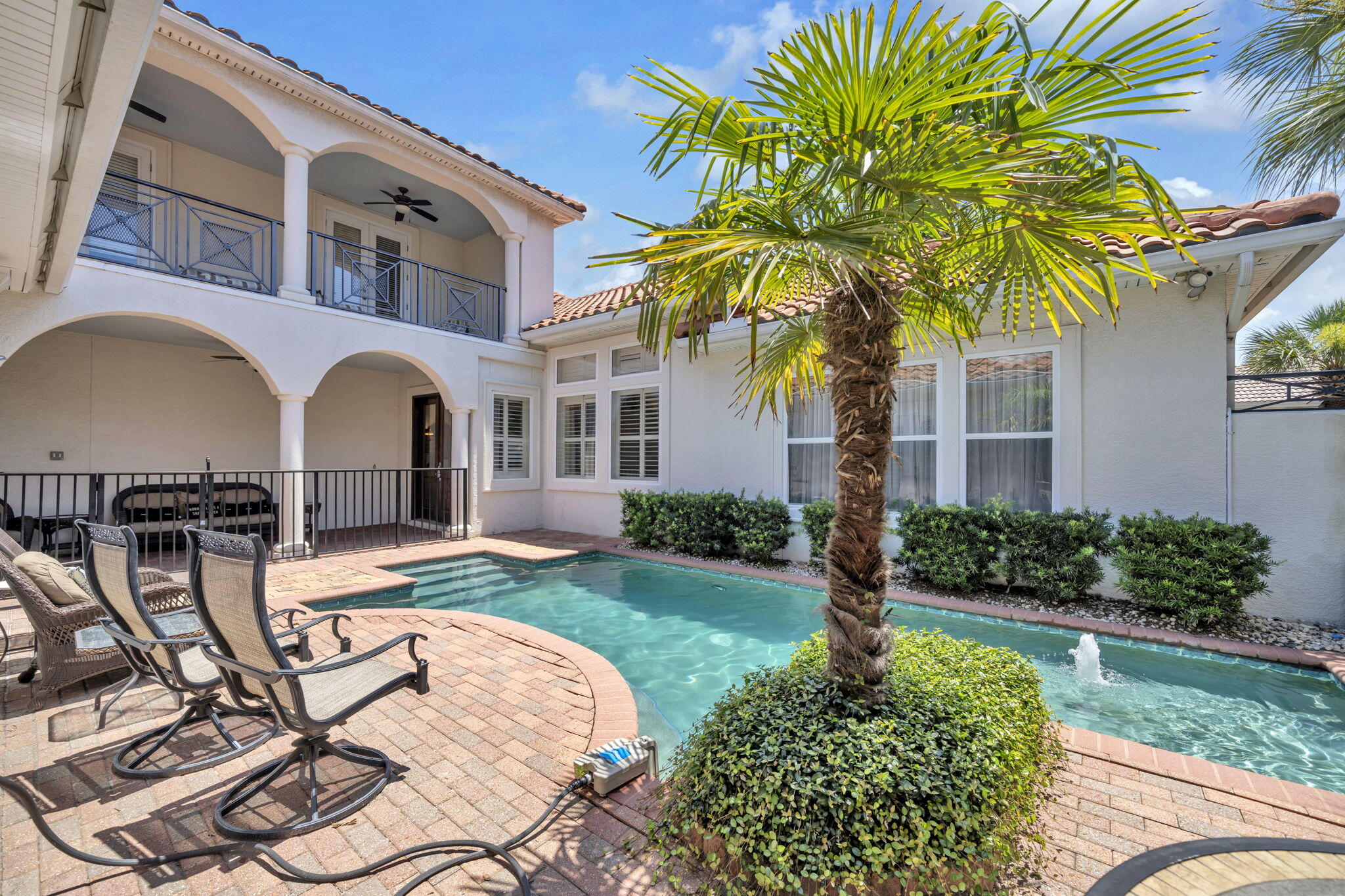 Experience the perfect blend of elegance, privacy, and resort-style living in this beautifully designed Mediterranean residence located within the highly sought-after gated community of Destiny East. Offering 5 bedrooms, 4.5 bathrooms, and approximately 3,821 square feet of thoughtfully designed living space, this exceptional home is perfectly suited as a luxury primary residence, second home, or income-producing vacation rental.

Currently operating on a successful vacation rental program, the property offers an outstanding opportunity for buyers seeking both lifestyle and investment potential in one of Destin's premier gated beach communities.

Centered around a stunning private courtyard, the outdoor living area features a sparkling pool surrounded by attractive paver decking, creating a private oasis for relaxing or entertaining. An outdoor kitchen makes hosting family and friends effortless, while multiple access points seamlessly connect the indoor and outdoor living spaces.

Inside, you'll find hardwood flooring, travertine tile, soaring ceilings, and an open-concept floor plan designed for comfortable coastal living. The spacious kitchen flows seamlessly into the main living and dining areas, creating the ideal setting for entertaining.  One of the home's standout features is the private guest suite with its own en-suite bath and direct access to the courtyard pool, providing exceptional flexibility for extended family, guests, or vacation rental groups seeking additional privacy.

Additional highlights include a spacious primary suite, generous guest accommodations, a 2-car garage, and two golf carts included with the sale, making trips to the beach and around the neighborhood both convenient and enjoyable.

Located just a short golf cart ride from the sugar-white sands and emerald waters of the Gulf, Destiny East offers residents and guests an exceptional amenity package, including a resort-style community pool, clubhouse, fitness center, tennis and pickleball courts, playground, walking trails, scenic lakes, and gated security.

Whether you're looking for a private coastal retreat, a full-time residence, or a turnkey vacation rental investment, 77 Siesta Bluff delivers the ideal combination of luxury, location, and income potential in one of Destin's most desirable communities. Buyer to verify all information