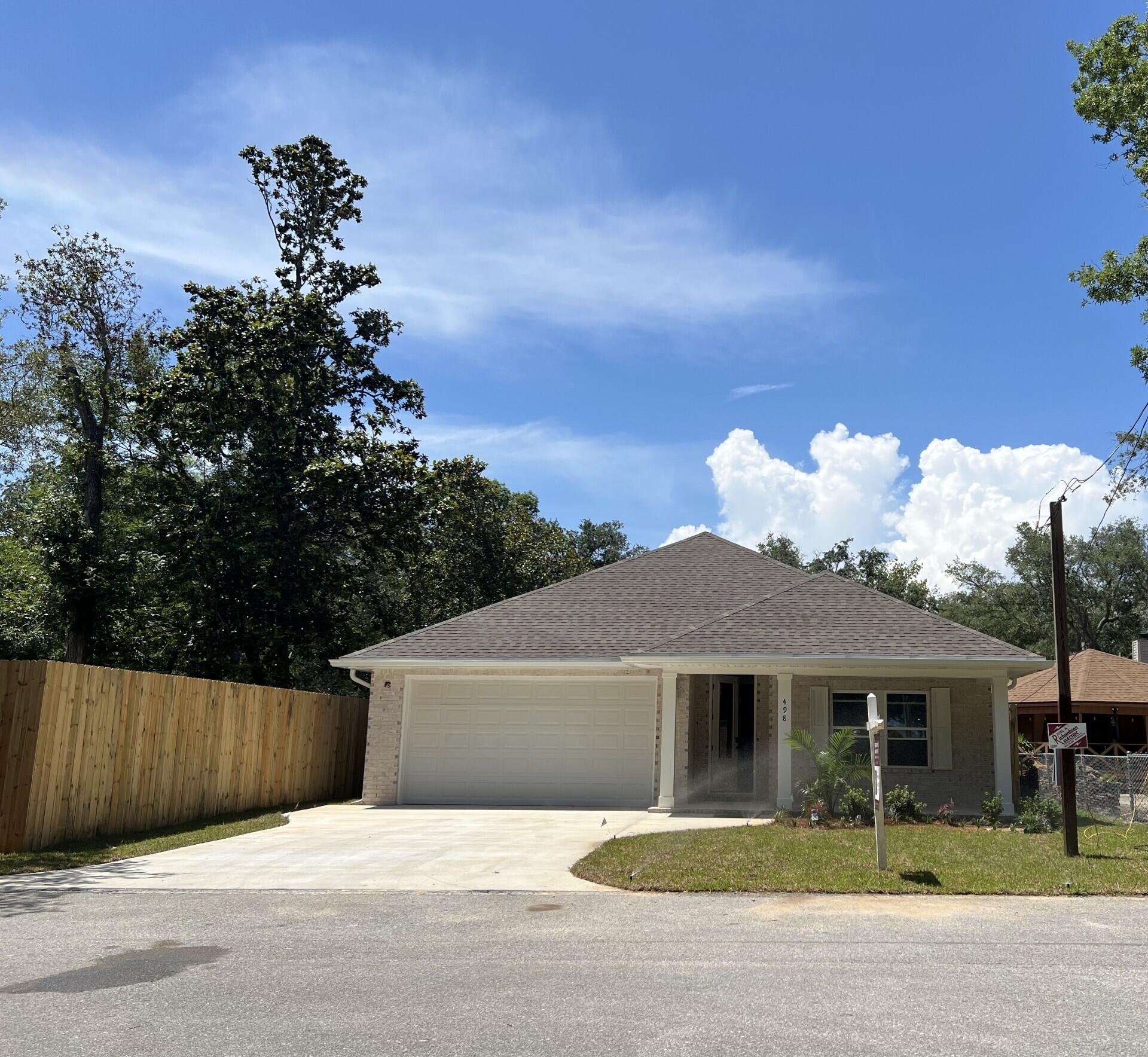 Stunning craftsmanship in this new construction all-brick 3-bedroom, 2-bath home. This modern home features 1,905 sq.ft. with high-end custom finishes and exceptional detail. Get settled into a neighborhood less than 2 miles East of Bluewater Bay and the Mid-Bay Bridge surrounded by new construction! This move in ready home blends timeless quality with today's most desired features, creating a home that is as functional as it is beautiful. Entering the home, you have an oversized foyer that immediately sets the tone for the custom finishes found throughout. Premium LVP flooring throughout the entire home, paired with crown molding and reverse trey ceiling with lighting, providing a seamless aesthetic.  Enter into the spacious living room with an open concept that provides an abundance of natural light with large high-impact windows, neutral finishes and modern lighting. Additional features include a floor outlet in the family room, perfect for lamps or phone chargers without obstructing walkways and the reverse trey with custom lighting with a remote providing a color choice for every season. The kitchen is a true show-stopper, designed with both style and functionality. Featuring white maple shaker cabinetry with soft-close drawers, a farm sink, white ceramic back-splash, quartz countertops, steele Whirlpool appliance package and a large walk-in pantry. The oversized 8ft island and the 6ft coffee bar add the perfect finishes! As you enter the spacious primary suite, you're greeted with natural light and you'll love the reverse trey with custom changeable lighting. Especially in the evening! The spa-like bathroom is beautifully accented with a 6ft soaking tub with shiplap accents, custom led lighting behind the mirrors with changeable colors. A custom-built full-length mirror and the spa-like shower features a built-in bench, rain head, front sprayer and a handheld sprayer conveniently placed beside the bench. Custom shelving makes the walk in closet perfect for organization. This split floor plan provides two more bedrooms and another full bath. Laundry, you will actually want to do the laundry, with a custom folding table with quartz countertop, and built-in shelving. When you want to relax, and rewind, the back yard is the place! You'll enjoy a screened in porch with ceiling fan, flood lights on each end of the house and an extra paver pad across the back of the home for a full patio set and grill. Maintenance is easily obtained with this fully sodded yard, sprinkler system that works off a separate well and a 8 ft. privacy fence with gutters installed. Theres an alley road for these homes that give an entrance to the back yard as well. A double gate has been installed on the back right side, ideal for ATV's, jet ski or a trailer. For energy efficiency, the builder has installed upgraded spray foam in the roof. You will also enjoy the storage above the garage along with the upgraded epoxy garage floor. This builder takes great pride in his homes and it shows! Five new homes are under construction. The builder is offering $10,000.00 towards the buyers closing cost, doc stamps on the deed, split title insurance and all title related fees. Restaurants, boat launch, Eglin Air Force Base, Special Forces, Emerald Coast beaches, shopping, hospitals and more are very close. Call today for a viewing, and Welcome Home