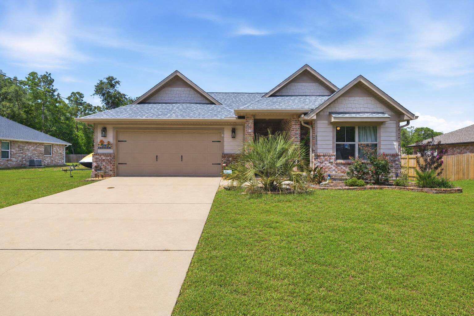 Peaceful country living with modern convenience! Located just off Garcon Point Road in desirable Flood Zone X, this beautifully maintained 2022 all-brick home sits on a spacious 0.30-acre lot with NO HOA, offering the perfect blend of privacy, comfort, and freedom. Featuring 3 bedrooms, 2 bathrooms, 2,044 square feet, and a 2-car garage, this home boasts a bright open floor plan with quality finishes throughout. The kitchen offers granite countertops, stainless steel appliances, solid wood soft-close cabinetry with dovetail drawers, oversized upper cabinets, and a range hood vented through the roof. Additional features include Low-E vinyl windows, recessed lighting, tile flooring in wet areas, and durable carpeting. The spacious primary suite includes a large walk-in closet, soaking tub, and separate shower. Outside, enjoy a covered front porch, covered back porch with ceiling fan, and upgraded Polyurea-coated patios. The backyard is pool-ready, with the septic system positioned to the side for maximum usable space. Additional upgrades include heavy-duty gutters, Nest thermostat, Arlo video doorbell, termite bond with Arrow Pest Control, extra electrical service for an RV, boat, or future generator hookup, and a storage shed that conveys. Perfectly located away from the hustle and bustle, yet only about 25 minutes from Pensacola, Navarre, and the area's beautiful white-sand beaches. This move-in ready home truly offers the best Florida living!
