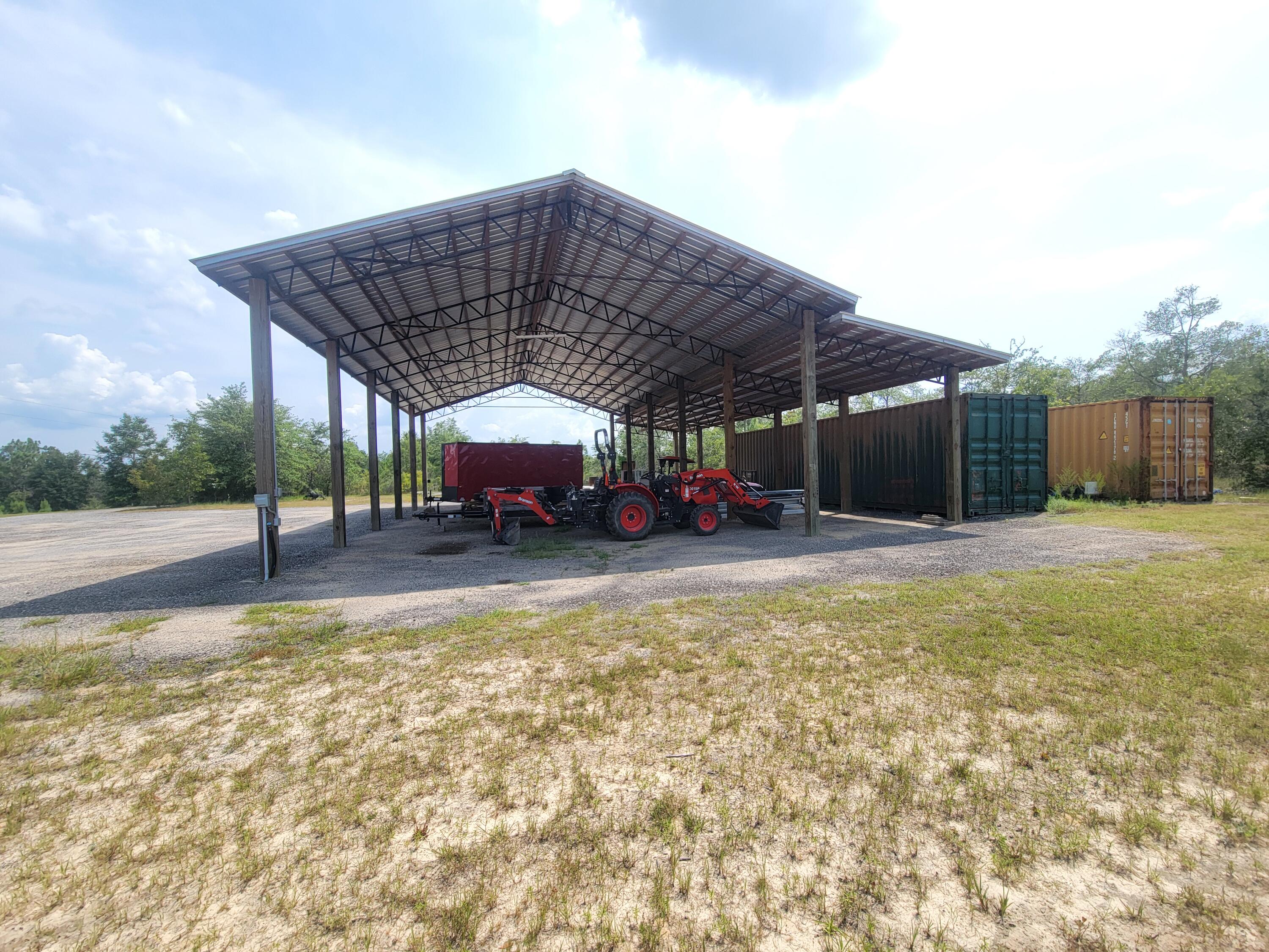 4 acre tract more or less on paved road, super size pole barn 60' x 44'  with  26 gauge metal roof,  8x8' posts, with  a 200 amp electrical box, and heavy gravel floor built 2021.  Included in the sales-- TWO - 8x40 containers, both are spray foam insulated  Property is partially cleared with several home sites to pick from to build your new dream home.  Please  call an agent to setup an appt. to view this property.