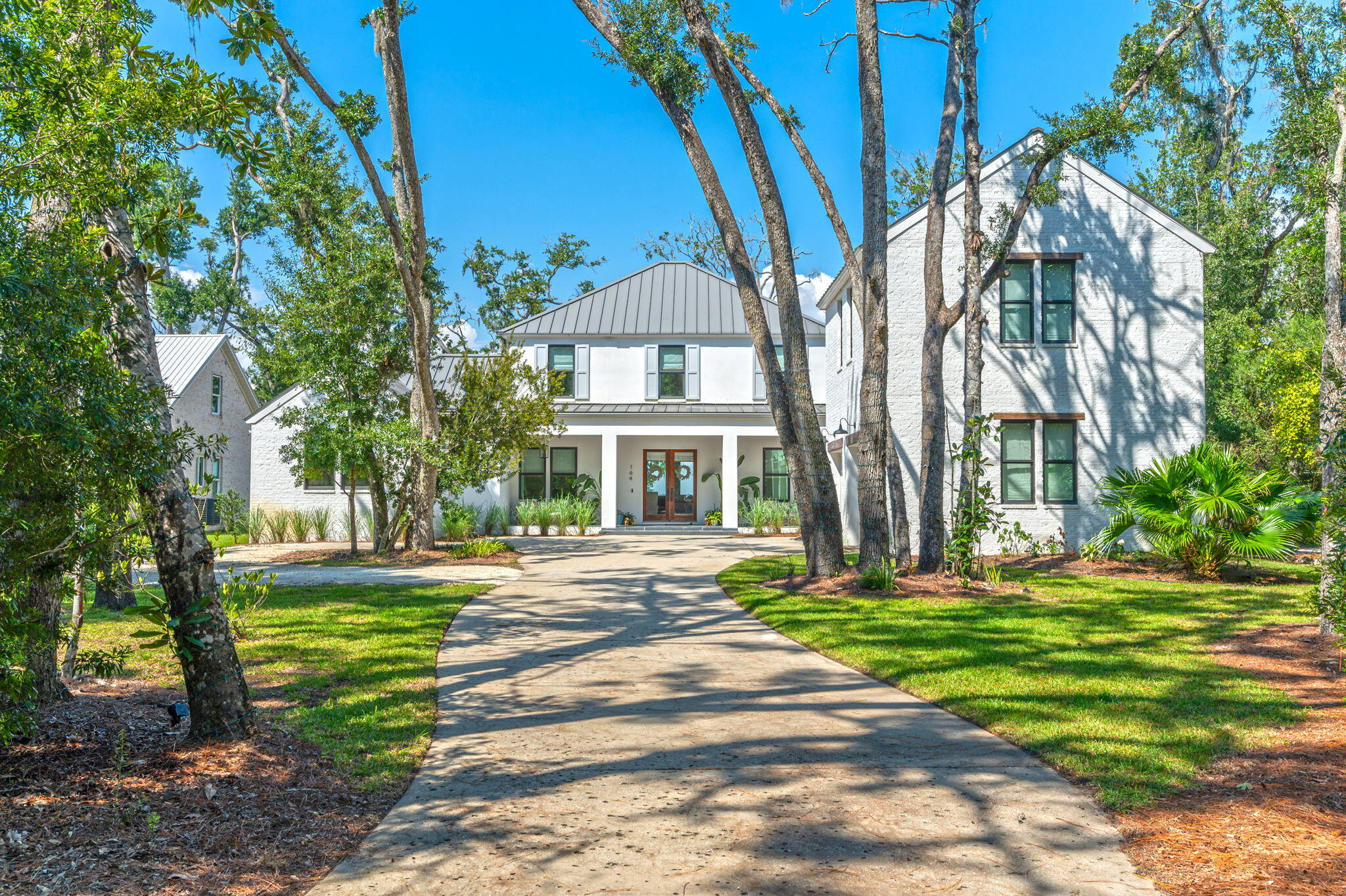 In The Woods, a carefully planned private, soon to be gated bayfront community in a natural wooded setting that preserves a perfect balance of nature, architecture, and relaxed luxury you will find this 
exquisitely crafted 5 bedroom 4,380 sq ft. estate residence on .72 acres and 95' of private bayfront, with expansive saltwater pool and boat dock equipped with a 12,000lb covered boat lift, 2 jet ski lifts, power, water, lights, and a lower dock to put in your SUP boards or kayaks for the pinnacle in luxury waterfront living and entertaining. Spend the day with family and friends in your bayfront pool watching the dolphins play, or on the water in the ultimate playground for boating and water recreation. Experience the best of both worlds, bay and beach, being located only 4 miles due north of Seaside. just minutes from the beach and the best dining and entertainment along Scenic Highway 30A. Arrive at the home located on a quiet cul de sac via a long driveway lined with grand oak trees and mature native growth with a roundabout for easy parking. Hosting a party? This home will accommodate at least 8 cars. Enter through a welcoming expansive porch to an impeccable home designed with chic natural elements of stone and light colored wood to blend with the tranquil environment in creating a warm relaxing atmosphere. You are greeted with breathtaking views of the Choctawhatchee Bay through a wall of double sliding glass doors where indoor and outdoor living come together..... The spacious living room has 10 foot ceilings, white oak floors, a gas fireplace and plenty of seating.The first floor primary bedroom is a peaceful retreat with serene views of the bay, a private screened porch with access to the pool area, a spa-like bathroom with dual vanities, a luxurious walk-in shower, deep soaking tub and expansive his and hers walk-in closets with custom built-ins. Off the hallway in the primary wing is also a comfortable light filled separate office, guest bedroom, or anything that best suits your needs.
The gourmet kitchen, adorned with quartzite countertops and waterfall on the island, Wolf gas range, built in Fisher and Paykel refrigerator & freezer, and ample floor to ceiling custom cabinetry, flows gracefully into a screened-in porch with an outdoor grill and sink which also accesses the large luxurious covered patio to relax in the shade by the pool or enjoy a glass of wine marveling at the spectacular sunset over the Choctawhatchee Bay. Behind the kitchen, you will discover a butler's pantry, a convenient powder bath, and a well-appointed laundry room. Ascend to the second level where a secondary living space/playroom with custom built-in desks awaits along with two bedrooms adjoined by a spacious Jack and Jill-style bathroom. An additional bedroom with en-suite bathroom unveils unparalleled bay views from the second floor. Above the two-car garage is a full carriage house for family members or guests that would enjoy some privacy in their own space, but still easily access the main home from inside by either a stairwell off the hallway from the kitchen or a side entrance, provides a gracious living room, a well-appointed bedroom, a convenient kitchenette, a dedicated laundry area, and a fully appointed bath. The Woods neighborhood also features only 44 homesites, minimal hoa dues and no short term rentals allowed. The home can even come furnished with a firm offer. This is a rare opportunity to own a legacy home in one of South Walton's most spectacular settings!