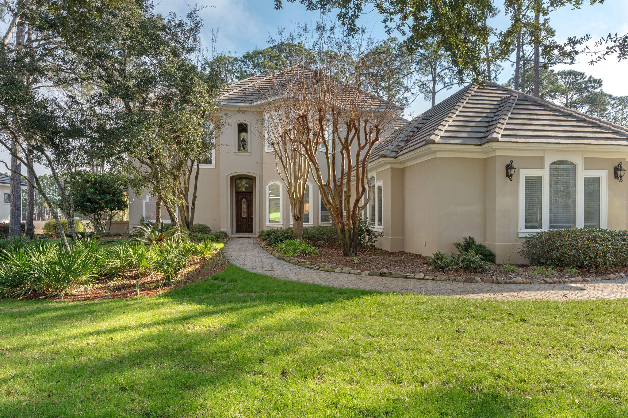 This distinguished custom-built residence is situated within the secure Burnt Pine Community on a private lot accented by mature oaks and meticulous landscaping, providing notable views of the natural preserve in a peaceful environment. The main level includes an elegant entry foyer, a gourmet kitchen with modern appliances, a formal dining area, a generous living room, a refined family room, a guest half bath, and a master suite featuring a full bathroom and direct access to a secluded outdoor jacuzzi. On the upper floor, three spacious bedrooms—one offering a private balcony—and a dedicated family or sitting area ensure ample accommodation. Thoughtful design elements include abundant storage, an oversized two-car garage, and a separate garage for golf carts.
