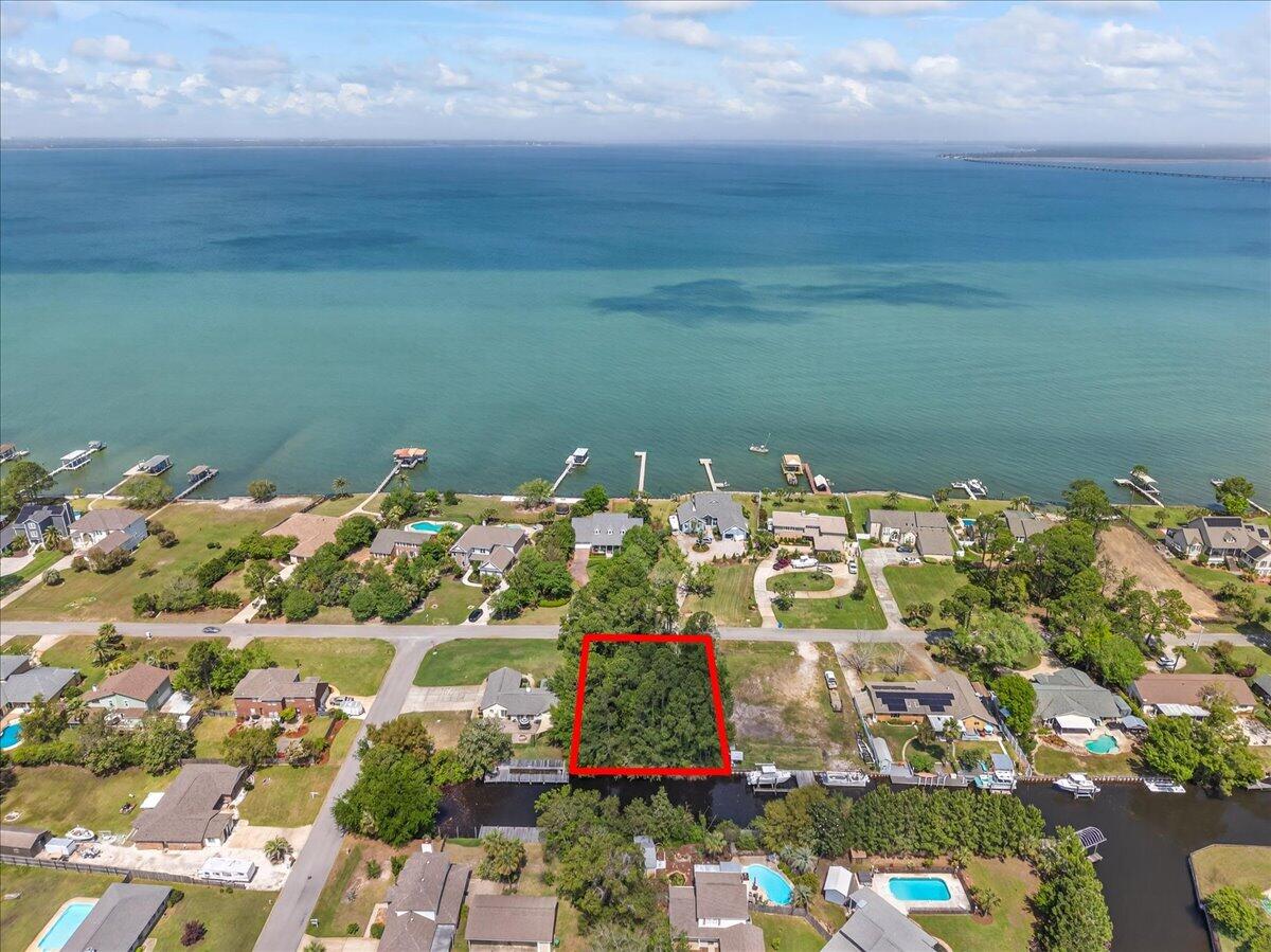 Create your ideal coastal retreat on this beautiful waterfront lot located along an 8-foot-deep canal in the heart of Gulf Breeze! With approximately 100 feet of canal frontage on a generous 0.28-acre parcel, you'll enjoy peaceful surroundings, stunning sunset views, and excellent fishing right from your backyard. Situated in the well-established Polynesian Islands neighborhood, this property offers a voluntary HOA and is surrounded by natural beauty, all within the highly sought-after Gulf Breeze K-12 school district. Tucked near the end of the canal, the location provides limited boat traffic for a quieter, more private waterfront setting. The lot is ready to be cleared and built on, with an existing survey available. Its layout is well-suited for a custom waterfront home complete with a pool, seawall, or boathouse. This is a rare opportunity to own a deepwater canal lot in a highly desirable coastal community!