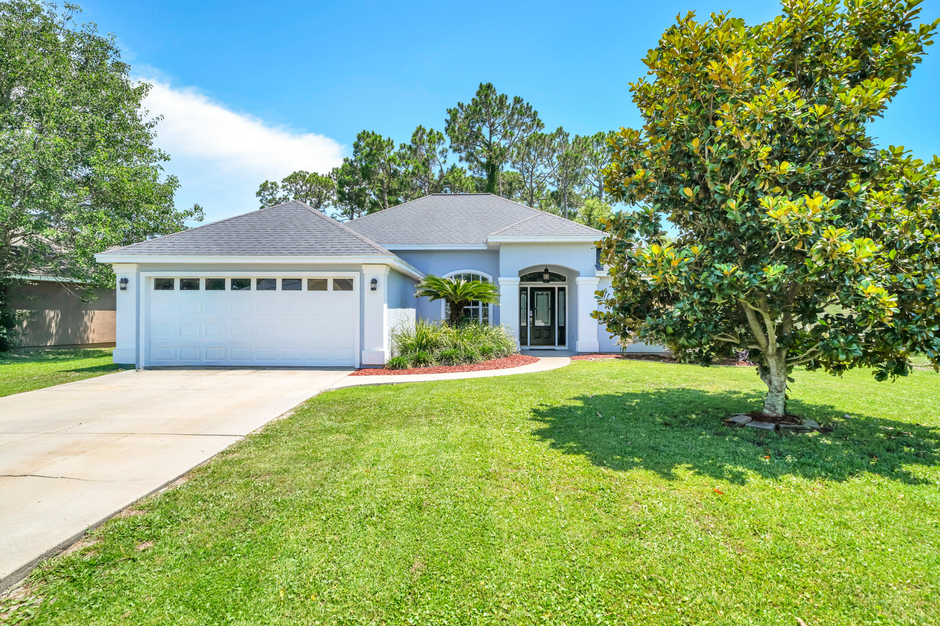 Pride of ownership is taken to a whole new level in this beautiful residence in the Hidden Pines neighborhood of Panama City Beach. Lovingly and meticulously maintained by its owner-occupant for over 20 years, this immaculate home delivers a rare combination of pristine quality, thoughtful updates, and an unbeatable location with no HOA dues. From the moment you arrive, exceptional maintenance is evident inside and out. Major exterior updates provide long-term peace of mind, including fresh elastomeric paint and updated stucco work (2024), replaced front door glass and sidelights (2021), and a 2018 roof. 

Inside, 1,701 sq. ft. of carpet-free living space features soaring ceilings, crown molding, fresh 2026 interior paint, brand-new lighting and ceiling fans, plus beautiful COREtec Plus LVP flooring. In addition to the 3 spacious bedrooms and 2 full bathrooms, the home includes a flexible Florida/bonus room fitted with its own newly added exterior door (2025), making it an ideal home office, flex room, or private guest space. The heart of the home centers around a cozy fireplace and a beautifully revamped kitchen equipped with brand-new granite countertops (2026), a sleek quartz composite sink, an under-sink water filtration system (2025), modern stainless steel appliances, updated plumbing fixtures, a dedicated dining area, and a light-filled breakfast nook featuring a newly replaced exterior window (2026). The primary suite serves as a true retreat with two walk-in closets, a double vanity, a frameless glass shower, a separate soaking tub, a newly added privacy window (2026), and upgraded toilet and plumbing fixtures.  

Outside, the property backs directly up to a peaceful, protected wooded preserve, providing a completely private backyard oasis with no rear neighbors. Enjoy the coastal breeze from your covered, screened-in porch, or take a scenic stroll along the community's convenient nature paths. Situated in a highly desired pocket of PCB just minutes from the Navy Base, premier shopping, local dining, and world-famous emerald waters, this meticulously updated home is completely move-in ready. Schedule your showing today!