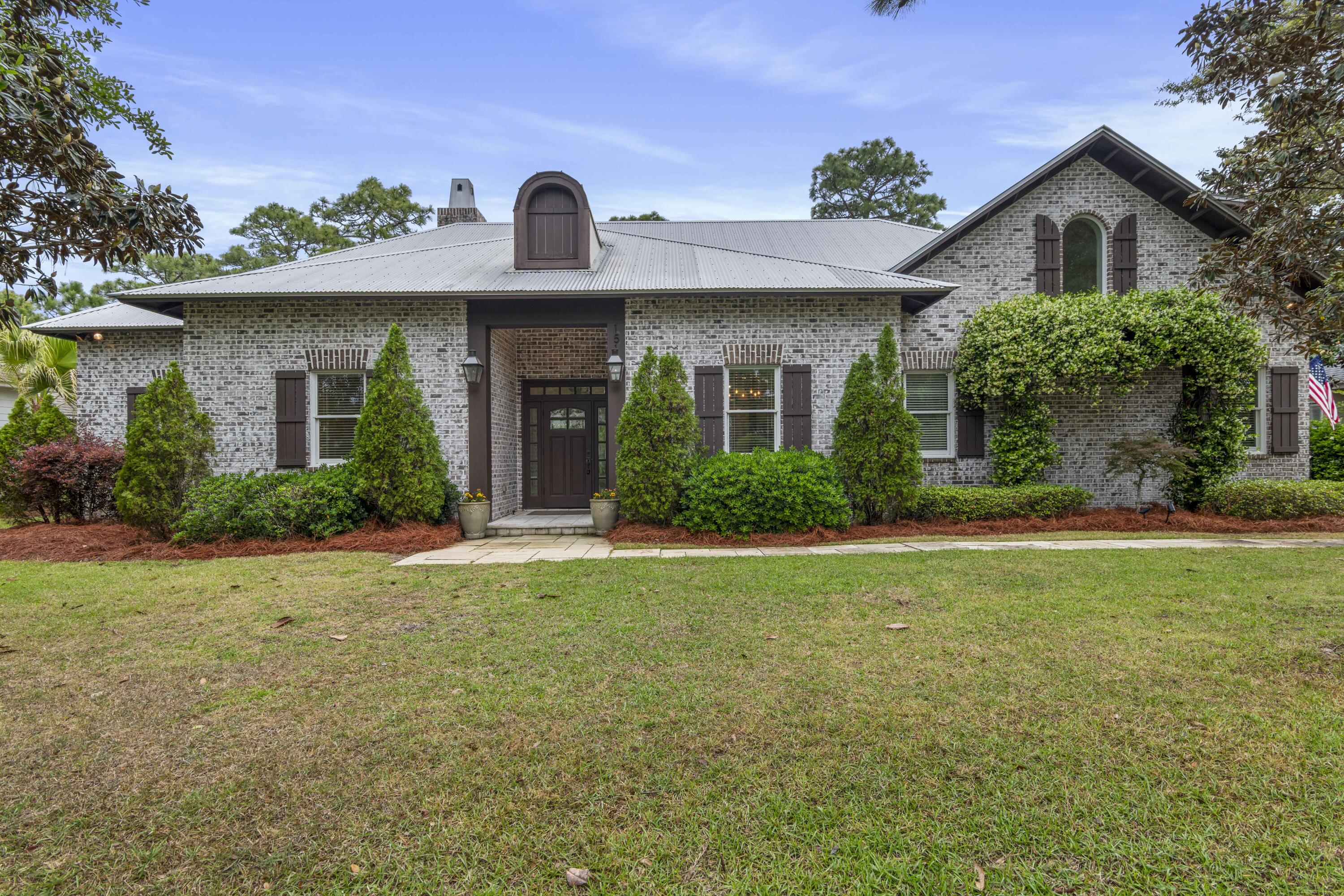 Tucked within the exclusive, gated waterfront community of Botany Bayou, this exceptional custom brick residence offers a rare blend of refined craftsmanship, privacy, and natural beauty. Backing to a protected state preserve, the home enjoys serene, unobstructed views and a tranquil setting that feels worlds away while remaining close to everything the Emerald Coast has to offer.

Thoughtfully designed with both everyday living and entertaining in mind, the home features 5 bedrooms and 4.5 bathrooms, including a versatile private suite above the two-car garage. Complete with its own full bath and an additional bonus/media or game room, this flexible space is ideal for guests, a home office, or multi-generational living.

Upon entry, you're welcomed by a warm and inviting foyer with accented reclaimed oak beams that continue into the kitchen and informal dining areas, setting the tone for the home's elevated yet comfortable aesthetic. The living room is a true showpiece, featuring a dramatic half-vaulted ceiling with transom windows that flood the space with natural light, along with a stunning floor-to-ceiling brick fireplace. From here, the home flows effortlessly to the screened back patio, creating a seamless indoor-outdoor living experience ideal for entertaining or relaxed evenings watching your favorite game.

The chef's kitchen is both striking and functional, showcasing premium Wolf appliances, a gas range, an eye-catching copper vent hood, and elegant marble countertops. Designed for gathering, it opens beautifully to the main living and dining areas.

The primary suite is a true retreat, highlighted by soaring ceilings and expansive windows that frame peaceful preserve views. The spa-inspired primary bath features dual marble-topped vanities, a classic clawfoot soaking tub, and a spacious walk-in shower with floor-to-ceiling tile surround. Additional bedrooms on the main level include a Jack-and-Jill layout as well as a private ensuite guest room, plus a conveniently located half bath.

Outdoors, the screened patio offers an inviting space for dining and entertaining, while the fully fenced backyard provides ample room for future enhancements, whether a pool, garden, or expanded outdoor living area, all while maintaining exceptional privacy thanks to the preserve backdrop.

Botany Bayou is a boutique, gated community known for its quiet, natural setting and limited number of homesites. Residents enjoy access to a private community dock on Hewett Bayou, perfect for kayaking, paddleboarding, or simply taking in the coastal scenery, as well as a community pool. For boating enthusiasts, both East Hewett Boat Ramp and Bay Circle boat ramp are conveniently located within 5 miles, offering easy access to the bay and beyond. Nature lovers and beachgoers will appreciate being just minutes from Topsail Hill Preserve State Park and Dune Allen Beach Access, providing quick access to scenic trails, rare coastal dune lakes, and the sugar-white sands of the Gulf.

This is an exceptional opportunity to own a meticulously designed home in one of Santa Rosa Beach's most serene and sought-after communities.