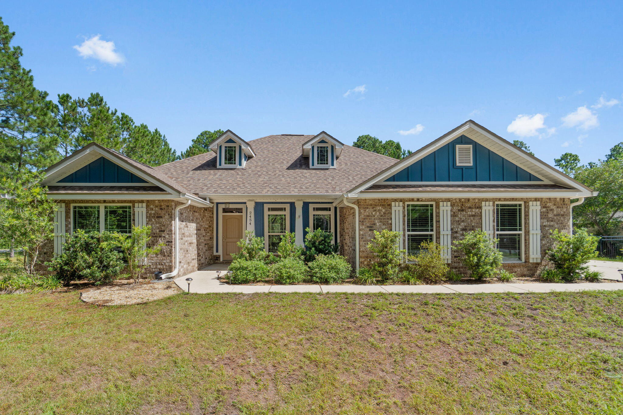 Beautiful craftsman Build on a huge Corner Lot  in Holley by the Sea! This gorgeous home sits on nearly 3/4 acres in a community with abundant amenities like a community room, boat launch, playground, and more! The inside features over 2,000 square feet including four bedrooms, two bathrooms, and an open living area, dining room, and kitchen. Tall, trey ceilings and plank tile floors flow throughout, highlighting the open concept, and large windows fill the rooms with natural light. The kitchen comes equipped with stainless appliances, rich wood cabinetry with soft close drawers, a mosaic backsplash, and granite counters that continue over the center island. Perfect yard for a pool and comes with a shed for storage.