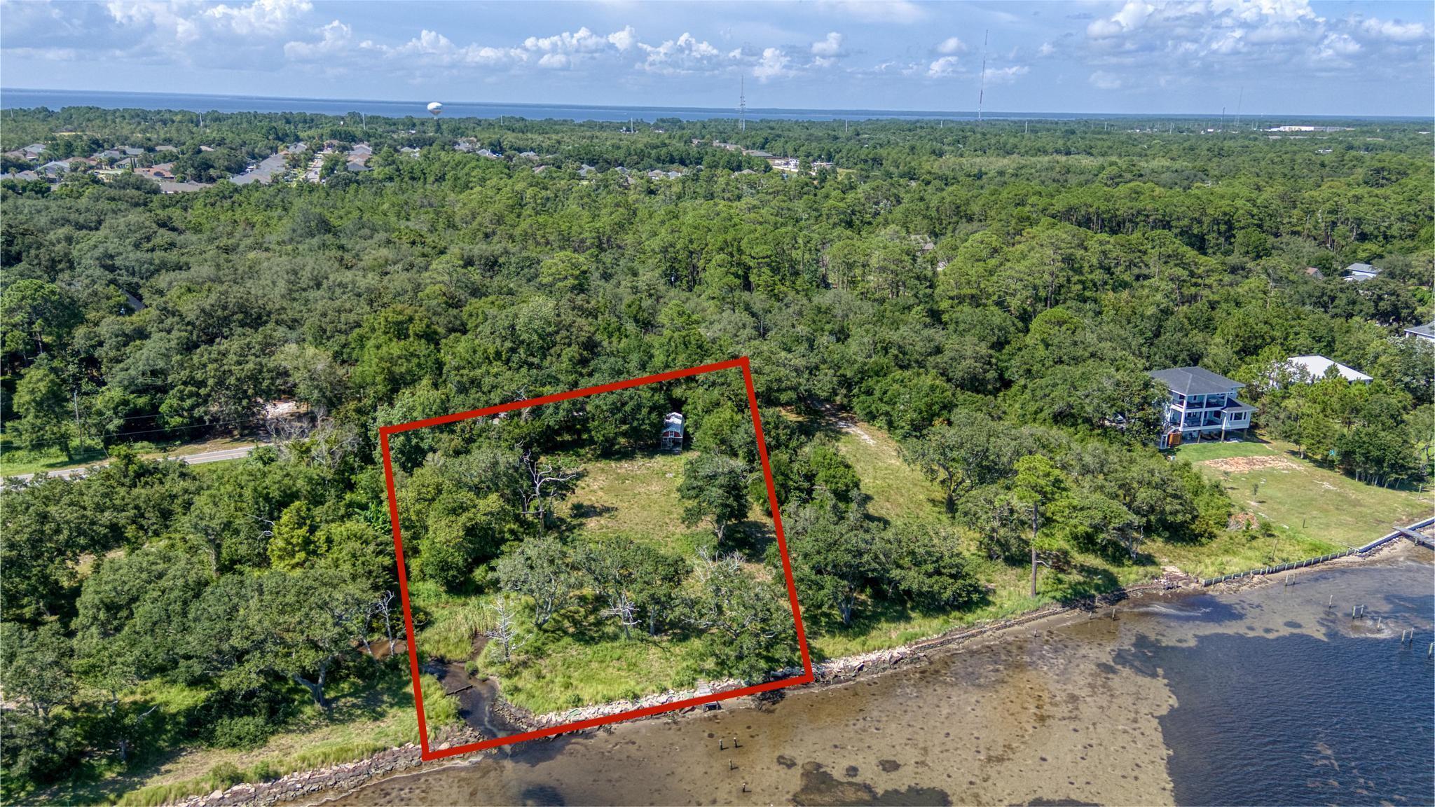 Exceptional Waterfront Opportunity on Soundside Drive - Nearly One Acre with Unmatched Views

Welcome to a rare and remarkable offering on one of the most coveted stretches of waterfront in the area. Located on Soundside Drive, this expansive lot spans approximately 0.94 acres and features an impressive 191 feet of water frontage--delivering panoramic, unobstructed views of the Gulf Islands National Seashore.

Nestled among mature majestic oaks and bordered by a natural creek along the western edge, this property offers built-in privacy thanks to a lush greenbelt. Along the shoreline, rip-rap has been strategically installed to prevent erosion, and remnants of a once 300+ ft dock (including several existing pilings) hint at the incredible potential for future waterfront enhancements. Steeped in local history, the property has yielded fragments of early pottery over the years, adding a layer of character and cultural value to this already extraordinary site. In addition to its natural beauty and privacy, the neighborhood offers exceptional amenities, including a public boat ramp and dock, perfect for boating and water activities. Outdoor enthusiasts will also appreciate the Soundside Nature Preserve, just moments away, offering scenic trails and serene views of the bay. Whether you envision a private estate home or a peaceful waterfront retreat, this lot provides the perfect blank canvas to bring your vision to life. Property is gated and locked--please contact the listing agent directly to schedule your private showing.