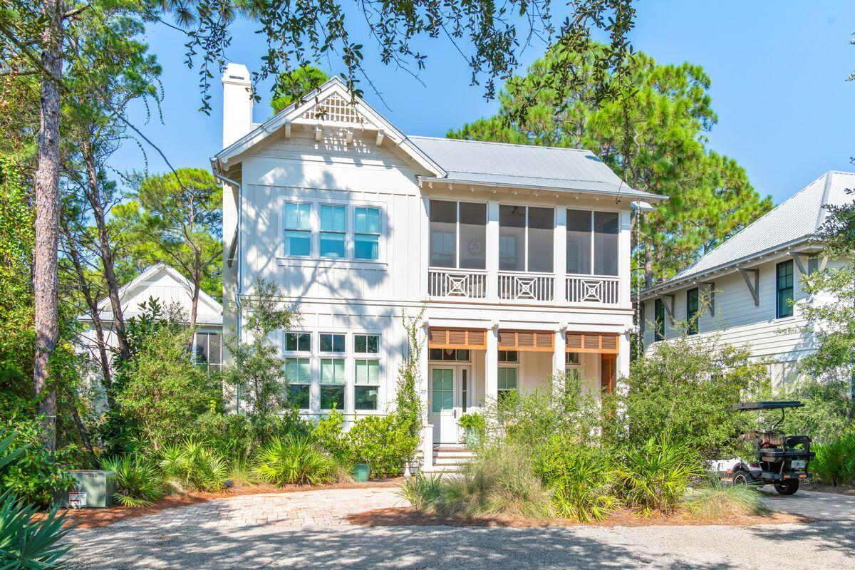 Tucked away in the quiet, gated community of The Hammocks of Seagrove, 27 Bramble Lane combines thoughtful architecture, exceptional craftsmanship, and one of the community's most desirable settings. Built in 2023 by Luke & Blue and designed by Archiscapes, this approximately 2,500-square-foot home offers four bedrooms and three-and-a-half baths, with a peaceful preserve behind the property and the community pool just across the street. Best of all, the sugar-white sands of Seagrove Beach are approximately a quarter mile away, and a golf cart is included for effortless trips to the beach and around 30A.

Inside, the home immediately feels different. Warm hardwood floors, extensive custom millwork, shiplap walls and ceilings, exposed wood beams, and a striking herringbone wood ceiling detail bring texture and character to the open living spaces. Oversized windows fill the home with natural light while impact-resistant windows add peace of mind. The living room centers around a fireplace framed by custom cabinetry and natural textures, while the adjoining dining area and kitchen create an easy flow for entertaining. A custom wet bar with beverage refrigeration adds both function and a beautiful architectural element to the space.

The main level includes a private guest suite with an ensuite bath and charming built-in window seat. Upstairs, the spacious primary suite is a true retreat, featuring a dramatic vaulted and beamed ceiling, fireplace,  and its own beverage center just outside the bedroom. The primary bath continues the home's elevated coastal aesthetic with a soaking tub, oversized walk-in shower, natural wood vanity, designer wallcovering, and thoughtfully selected fixtures and finishes.

Two additional bedrooms complete the second floor and share a bath, including a cleverly designed bunk room with twin bunks above a king bed--an ideal arrangement for visiting family and friends. Throughout the home, custom cabinetry, designer lighting, natural materials, and individually selected finishes create a collected look that feels sophisticated without losing the relaxed character of a beach home.

Outdoor living includes welcoming porches, a screened second-floor porch, and an outdoor shower, while the preserve directly behind the home creates a sense of privacy that is increasingly difficult to find this close to the beach. With the community pool steps from the front door, there is no private pool to maintain--simply walk across the street and enjoy.

Sold furnished and offering short-term rental flexibility, 27 Bramble Lane works equally well as a beautifully appointed second home or a luxury vacation rental. Its location in Seagrove puts the beach, dining, shopping, and everything along Scenic Highway 30A within easy reach, yet at the end of the day, the home offers what its owners have valued most: a quiet place to retreat, surrounded by nature and just minutes from the Gulf. Buyer to verify all information and dimensions.
