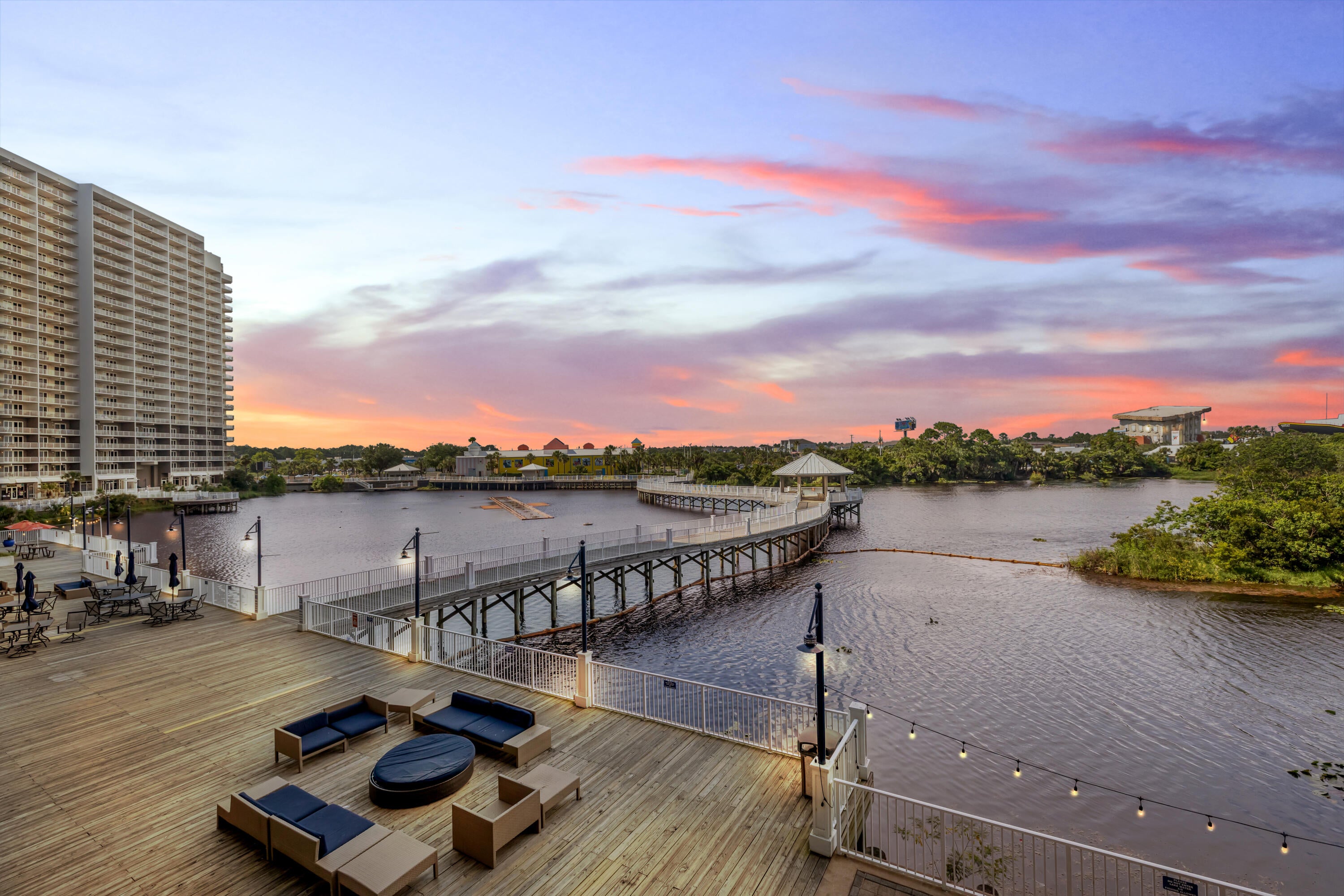 WHIMSICAL COASTAL STYLE. LAKEFRONT BALCONY VIEWS. FIRST RESIDENTIAL LEVEL CONVENIENCE.
Laketown Wharf 108 is beautifully updated, thoughtfully styled, and full of beach-inspired personality. This spacious three-bedroom, two-bathroom split-bedroom floor plan has been extensively refreshed within the past year. From the furnishings and décor to the lighting, finishes, and updated details, this residence is move-in ready and equally suited as a primary residence, second home, or vacation rental investment.
The primary suite overlooks the lake and features sliding glass door access to the large balcony. The ensuite bathroom includes double vanities, a soaking tub with decorative tile surround, a large walk-in shower, and updated fixtures.
On the opposite side of the residence, a guest bedroom and bunk room share a full bathroom, creating privacy for owners and guests alike.
A modern barn door with frosted glass panels provides privacy to the bunk room while also concealing the full-size stacked front-load washer and dryer. Throughout the residence, you'll find updated faucets, fresh paint, new lighting, ceiling fans, flat-screen TVs, and polished coastal décor with a distinctive Mermaid Cove feel. The owner's attention to detail is evident throughout, and the combination of furnishings, colors, lighting, and décor creates a residence that feels curated, memorable, and ready to enjoy from day one. The kitchen has been thoughtfully updated with River White granite countertops, an extended granite island with beveled corners, tile backsplash, all-new stainless-steel appliances, a deep undermount stainless steel sink, and an upgraded designer faucet. Luxury vinyl plank flooring runs throughout the living areas, with tile flooring in the bathrooms.
Step outside onto the oversized balcony, fully furnished with a dining table and multiple seating areas overlooking the Laketown Wharf boardwalk, lake, and the famous nightly fountain show.
From the primary bedroom and balcony, you'll also enjoy views of the iconic WonderWorks Upside Down House and Ripley's Believe It or Not!, two of Panama City Beach's most recognizable landmarks.
Located on the first residential level, this residence offers convenient access without depending on elevators, although the elevators are located near the front door. The unit is also conveniently positioned near the owner's parking garage.
Additional improvements include a new water heater installed in 2025 and a brand-new HVAC system installed in June 2026.
This residence is owner-occupied and meticulously maintained. Some personal items do not convey with the sale.
Laketown Wharf is known for its extensive amenity package, including five pools, two hot tubs, a Gulf-view fitness center, pickleball courts, mini golf, a playground, and a 52,000-square-foot boardwalk surrounding the lake with a nightly fountain and light show. The property also offers gated beach access next door to Pineapple Willy's, on-site dining and entertainment, two parking garages, barbecue areas, pet areas, and additional resort conveniences. HOA dues are $1,065.20 per month and include water, sewer, trash, cable/TV, pest control, WiFi, and access to amenities. All information is deemed reliable but should be verified by the buyer if important.