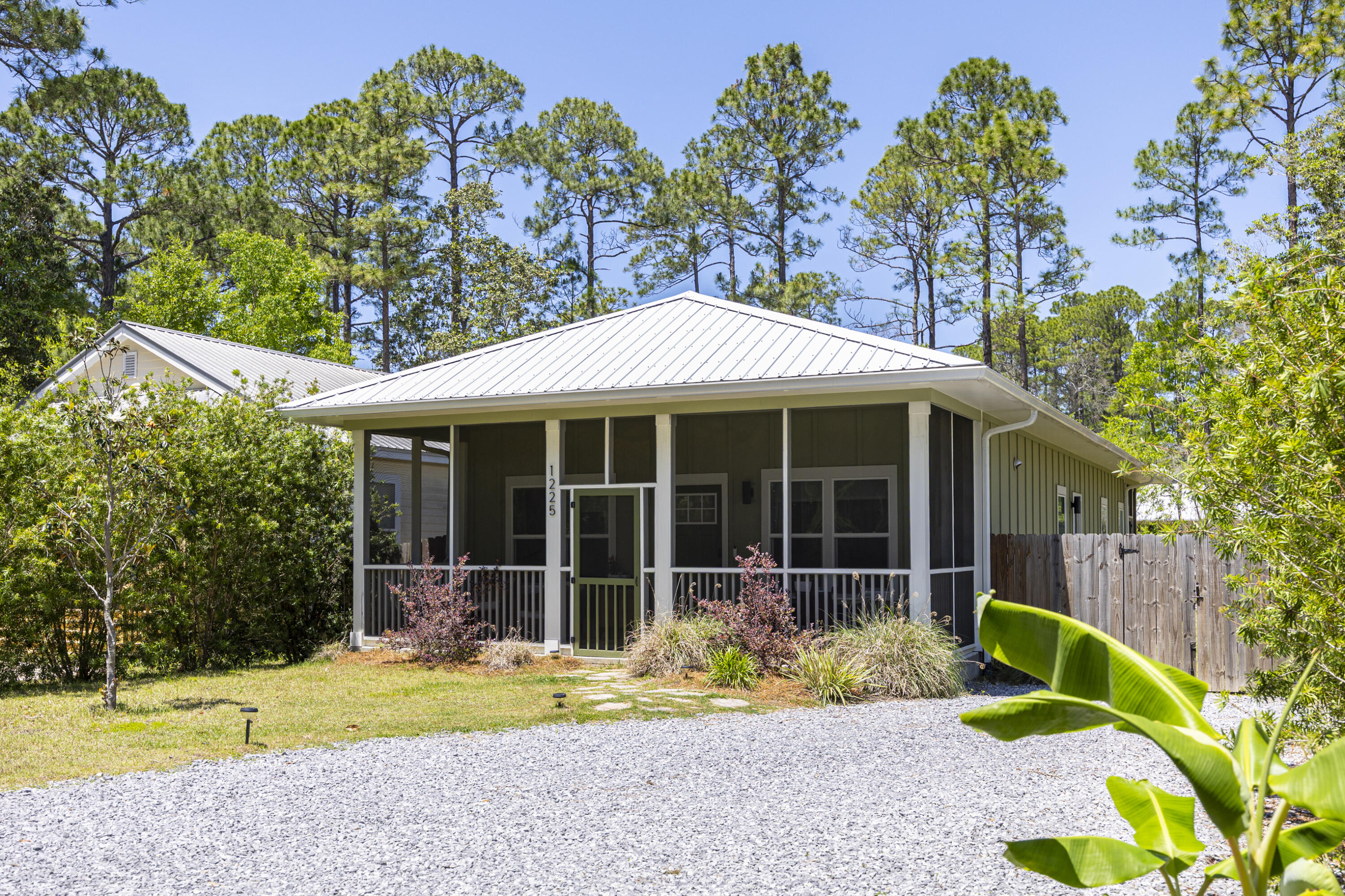Custom built 3-bedroom Florida cottage with a metal roof, modern farmhouse charm and a prime lot ideally positioned across from the state forest. Located in the laid-back Magnolia Beach community with no HOA, this Point Washington home offers a peaceful setting close to Choctawhatchee Bay, while being just 4-5 miles from 30A, Grayton & Seagrove Beach. Attractive landscaping, board and batten siding, and a gravel driveway enhance the curb appeal, while the screened-in front porch creates the perfect spot for outdoor dining or morning coffee with tranquil forest views. Inside, the open-concept layout is filled with natural light and enhanced by ~15 foot vaulted ceilings, creating a bright and spacious feel throughout the home. Luxury vinyl flooring flows seamlessly from room to room, while thoughtful upgrades like non-toxic paint & water filtration add to the home's appeal. The kitchen blends style and function with a Quartz island, farmhouse sink, stainless appliances, custom backsplash, floating shelves, and elegant pendant lighting, all complemented by calming forest views. The spacious primary suite offers vaulted ceilings, direct access to the screened porch, a walk-in closet, and a beautifully designed ensuite bath featuring a double vanity, oversized shower, soaking tub & impressive wet room with subway tile extending to the ceiling. Enjoy an additional 436 square ft. of screened porch space between the front & back porches, creating multiple areas to relax or entertain. The fully fenced backyard offers space to play, entertain, or garden with planter boxes, mature landscaping, fragrant jasmine, and a storage shed for added convenience. Enjoy close proximity to Choctawhatchee Bay, the neighborhood park at the end of N 283, and Grayton Dunes Beach Access with its scenic boardwalk, showers, tram service, boat launch, and access to Western Lake, one of South Walton's rare coastal dune lakes. Popular local spots including Chiringo and the iconic Red Bar are also nearby, making this an ideal opportunity to enjoy the relaxed coastal lifestyle of Point Washington and 30A.