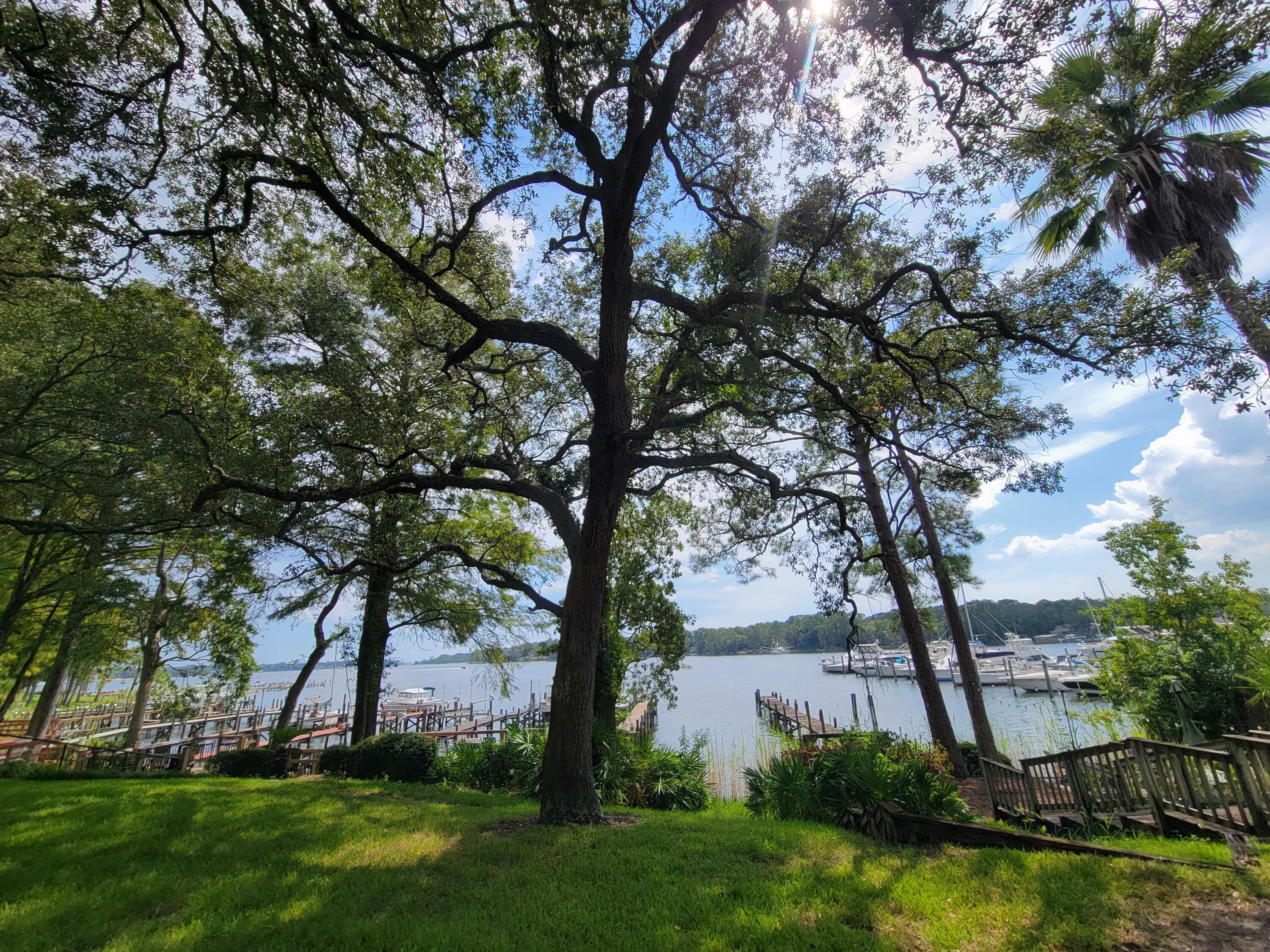 Waterfront Townhome on Boggy Bayou.  Experience premier waterfront living in this Boggy Bayou townhome, offering direct deep-water access and flexible space for full-time residents, second-home buyers, or boating enthusiasts. The private dock is ideal for fishing, enjoying sunsets, or setting out for the Gulf of Mexico, while scenic bayou views enhance the kitchen and main living area. Upstairs, the primary bedroom and bathroom open to a private balcony with exceptional views; this level also includes a second bedroom, and an additional full bathroom, and a laundry area. A smaller bedroom is located downstairs as well as  the half bathroom. The main-floor kitchen and living area feature a welcoming corner fireplace. Outdoor entertaining spaces include a lower-level porch with a built-in wet bar and a waterfront patio. Community amenities include nearby tennis courts, a recently repaired and resurfaced swimming pool, and fenced storage for RVs, boats, and trailers, available. Stroll beneath mature oaks and magnolias, watch dolphins in the bayou, and enjoy the immediate lifestyle appeal and long-term potential of this distinctive property. Favorable seller-financing terms are available.