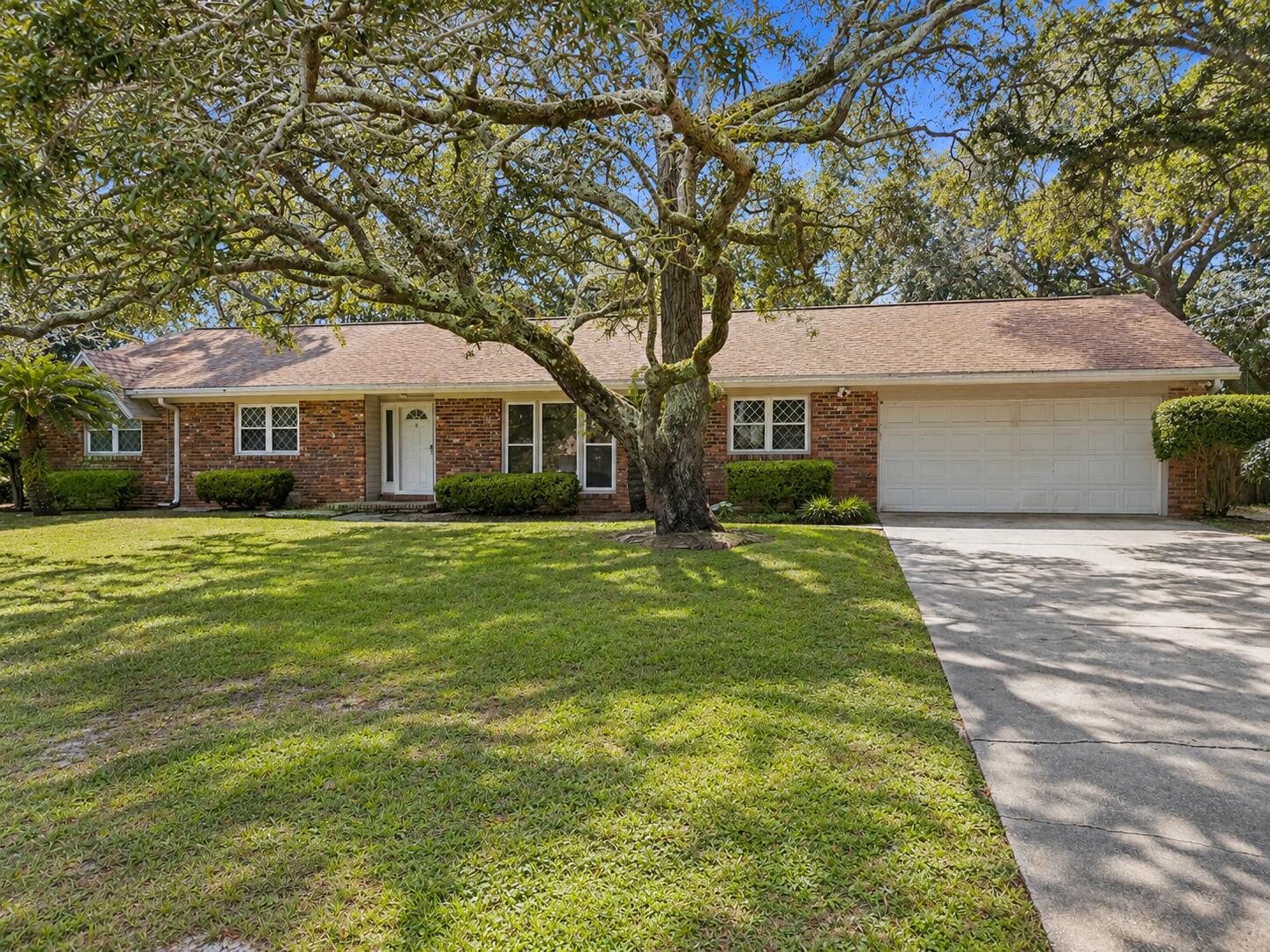 Welcome to 22 Country Club Road, a spacious 4-bedroom, 2-bath brick home ideally situated in the desirable Shalimar Pointe area. Offering approximately 2,010 square feet, this home combines comfortable living spaces with an unbeatable location directly across from the bay and overlooking the Shalimar Pointe golf course. Inside, you'll find a welcoming layout featuring two living areas, including one with a wood-burning fireplace, a formal dining room, and a beautifully updated eat-in kitchen with breakfast bar. The primary suite enjoys peaceful golf-course views, while an additional bedroom features French doors leading to the covered porch. Outside, the fenced backyard offers a covered porch--perfect for relaxing or entertaining while enjoying the mature landscaping and golf-course setting. With an attached 2-car garage and convenient access to Eglin AFB, Fort Walton Beach, Choctawhatchee Bay and area beaches, this Shalimar gem offers the best of Northwest Florida living. This includes yard maintenance. Photos are virtually staged. Tenant to provide own furnishings.