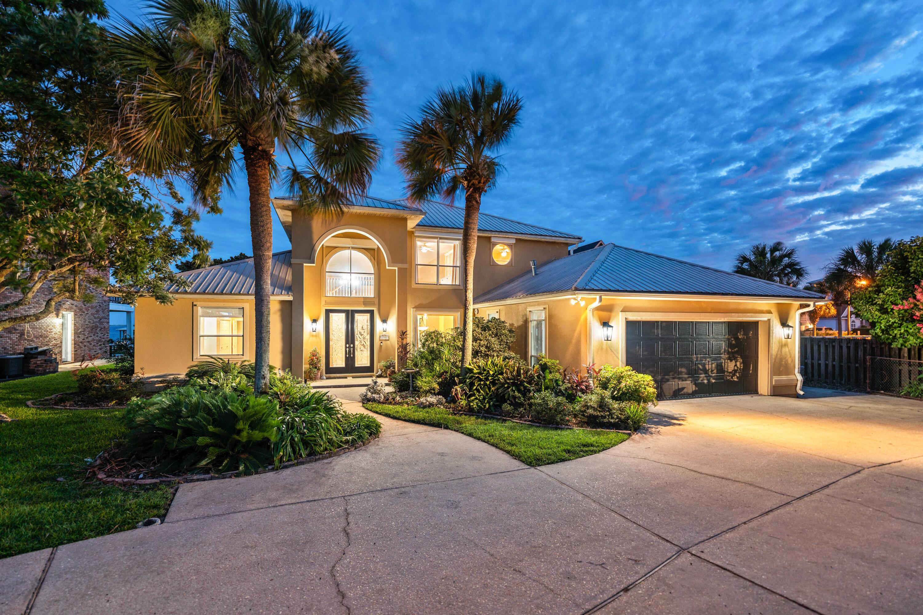 Ninety-three feet of Santa Rosa Sound frontage unfolds before you the moment you arrive. A 300-foot private dock stretches toward open water, a covered boathouse waits at its end, and a screened-in pool offers a front-row seat to the Sound -- all within Flood Zone X, the federal government's lowest-risk flood classification. 

This is not a compromise. This is the waterfront life, fully realized, on one of Navarre's most coveted sound-front lots.
Set on a sound front lot, 1901 Catamaran Dr is a custom executive residence where soaring 18- and 20-foot ceilings frame uninterrupted water views, and every detail has been considered with intention. The chef's kitchen commands the main level -- outfitted with a natural gas range, warming drawer, dedicated ice maker, wine fridge, trash compactor, dual prep stations, and a walk-in pantry with floor-to-ceiling shelving -- all while framing live views of Santa Rosa Sound. Bar seating for four. A formal dining room and casual dining area for every occasion.

The primary suite is a private sanctuary: bamboo wood floors, a dedicated sitting area, direct patio access, a garden tub, a separate tile shower, dual vanities with ample storage, and his-and-hers closets. The screened pool deck offers a front-row seat to the Sound, with an 8-foot-deep pool and a poolside half bath just steps away. Elsewhere: a gas fireplace in the great room, built-in speakers throughout communal spaces, porcelain tile, central vacuum, and a 2nd-floor flex space with custom built-ins. Auto hurricane shutters, full-perimeter storm protection, gutters, seawall, riprap, and a private sandy beach area.

Waterfront & Outdoor 
93 ft of Santa Rosa Sound frontage | 300-ft private dock with covered boathouse | Seawall, riprap, and private sandy beach area | Soundfront screened-in pool -- 8 ft max depth | Poolside half bath | Oversized circle driveway with parking for 6+ vehicles | Dedicated boat and/or RV parking on west side | Master gardener-designed landscaping | Well water irrigation system

Garage & Utility 
2-car garage with workbench and shop sink |  Central vacuum throughout | Natural gas range and gas dryer | Tankless water heater | All smoke detectors dual-certified (CO)

Kitchen 
Natural gas range | Warming drawer | Dedicated ice maker | Wine fridge | Trash compactor | Main sink and prep sink | Bar seating for 4 | Formal and informal dining areas | Large walk-in pantry with full surround shelving | Sound views from the kitchen

Interior 
18-ft entry foyer ceiling | 20-ft great room ceiling | Porcelain tile throughout main living areas | Bamboo wood floors in primary suite | New carpet -- under 18 months | Gas fireplace | Built-in speakers in communal areas | Uplighting and under-cabinet lighting in kitchen | Kick lighting in primary bath | 2nd-floor flex space with built-in cabinetry and shelving | Split bedroom floor plan

Systems
Tankless water heater | Auto hurricane shutters on two high windows | Storm shutters on all windows | Full gutters | Natural gas (range, dryer, fireplace, water heater)

Location 
8 min to Navarre Beach | 15 min to Gulf Islands National Seashore | 40 min to Destin-Fort Walton Beach International Airport | 45 min to Pensacola International Airport