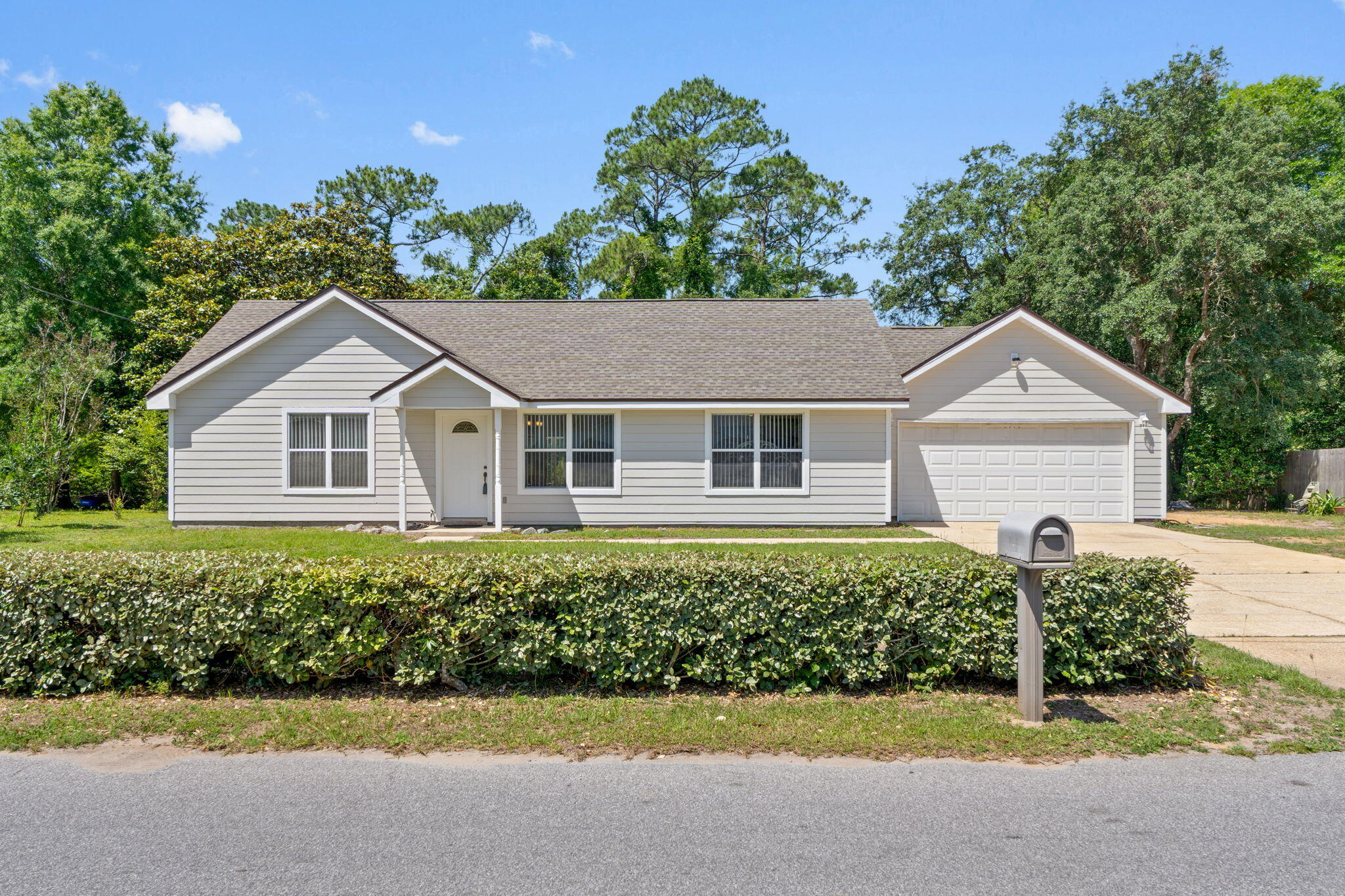 Welcome to this beautifully maintained home in the heart of Navarre, ideally located within walking distance to local schools and just minutes from shopping, dining, and the sugar-white beaches of the Emerald Coast! Combining comfort, functionality, and outdoor charm, this move-in ready property offers the perfect blend of convenience and coastal living.  Inside, you'll love the open floor plan with a split bedroom design, creating a spacious flow while still offering privacy where it matters most. The kitchen is equipped with stainless steel appliances, including a double oven, making it perfect for everyday living and entertaining alike. The living and dining spaces seamlessly connect and open to a covered patio overlooking the backyard retreat.  Step outside and enjoy the peaceful creek running behind the property, along with a fenced yard, greenhouse, and storage shed...perfect for gardening, pets, hobbies, or simply relaxing outdoors. Major updates include a brand new roof in 2026, all exterior wood replaced with durable Hardie board siding, and the septic recently pumped for added peace of mind.  With a 2-car garage, thoughtful updates, and a location that places you close to everything Navarre has to offer, this home is the total package!