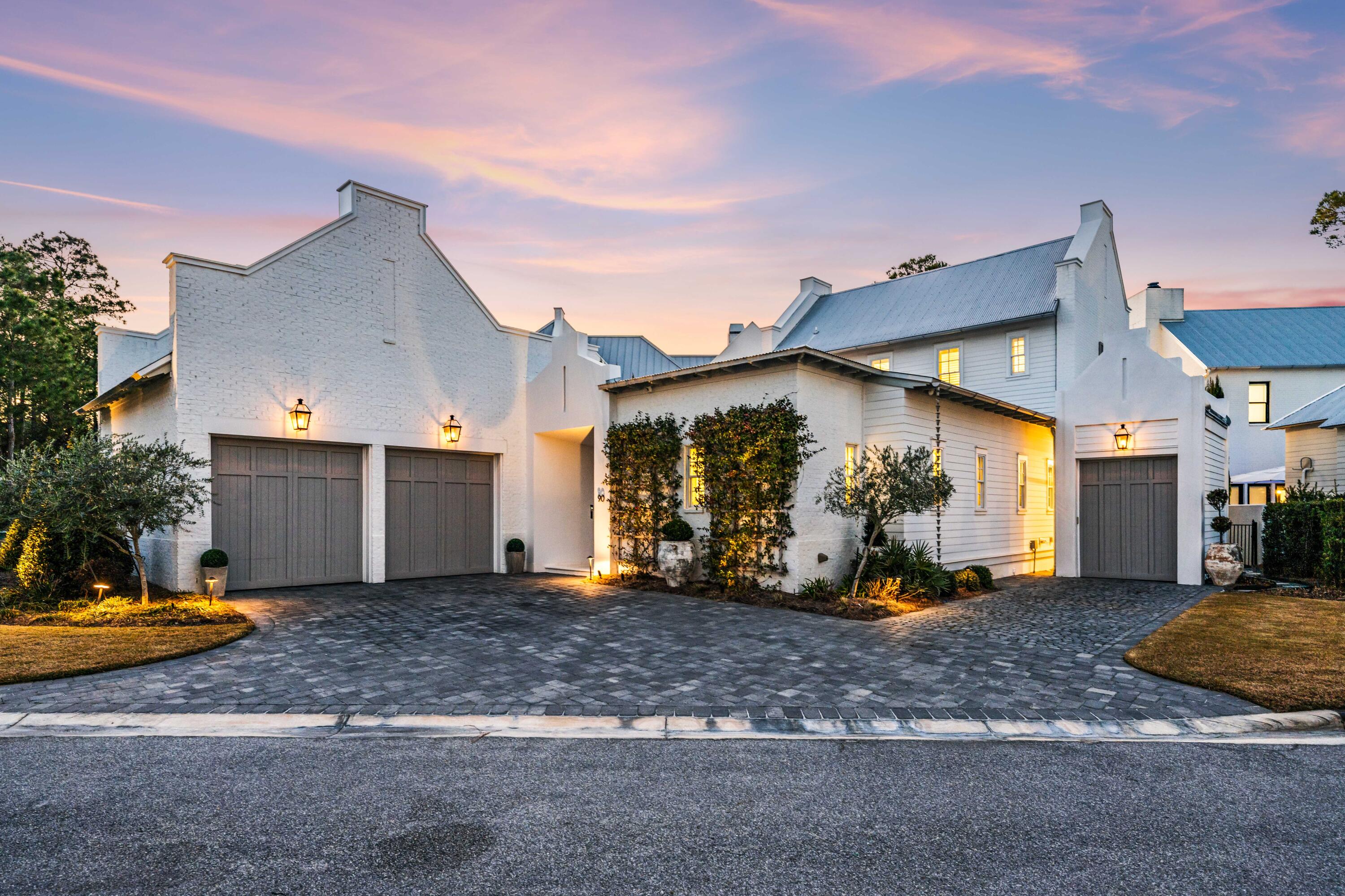 Set within the exclusive waterfront neighborhood of Churchill Oaks, 90 Perrin presents a masterfully designed coastal residence defined by sophistication and scale. Offering 2,988 square feet of heated and cooled living space and 4,385 square feet under roof, this two-story retreat is framed by gracious porches, a fully equipped summer kitchen, and multiple garage bays for seamless indoor-outdoor living.

At the heart of the home, a chef's kitchen showcases a professional-grade Wolf range, premium Liebherr appliances, quartz surfaces, and abundant custom cabinetry flowing effortlessly into a dramatic great room with 12-foot ceilings and an elegant fireplace centerpiece.

The primary suite is a serene sanctuary featuring a generous walk-in wardrobe and a spa-caliber bath designed for relaxation. A private courtyard offers a tranquil backdrop for intimate gatherings, while the air-conditioned two-car garage and dedicated golf cart garage provide both comfort and practicality. A whole-house generator and advanced water filtration system further elevate the home's standard of luxury living.