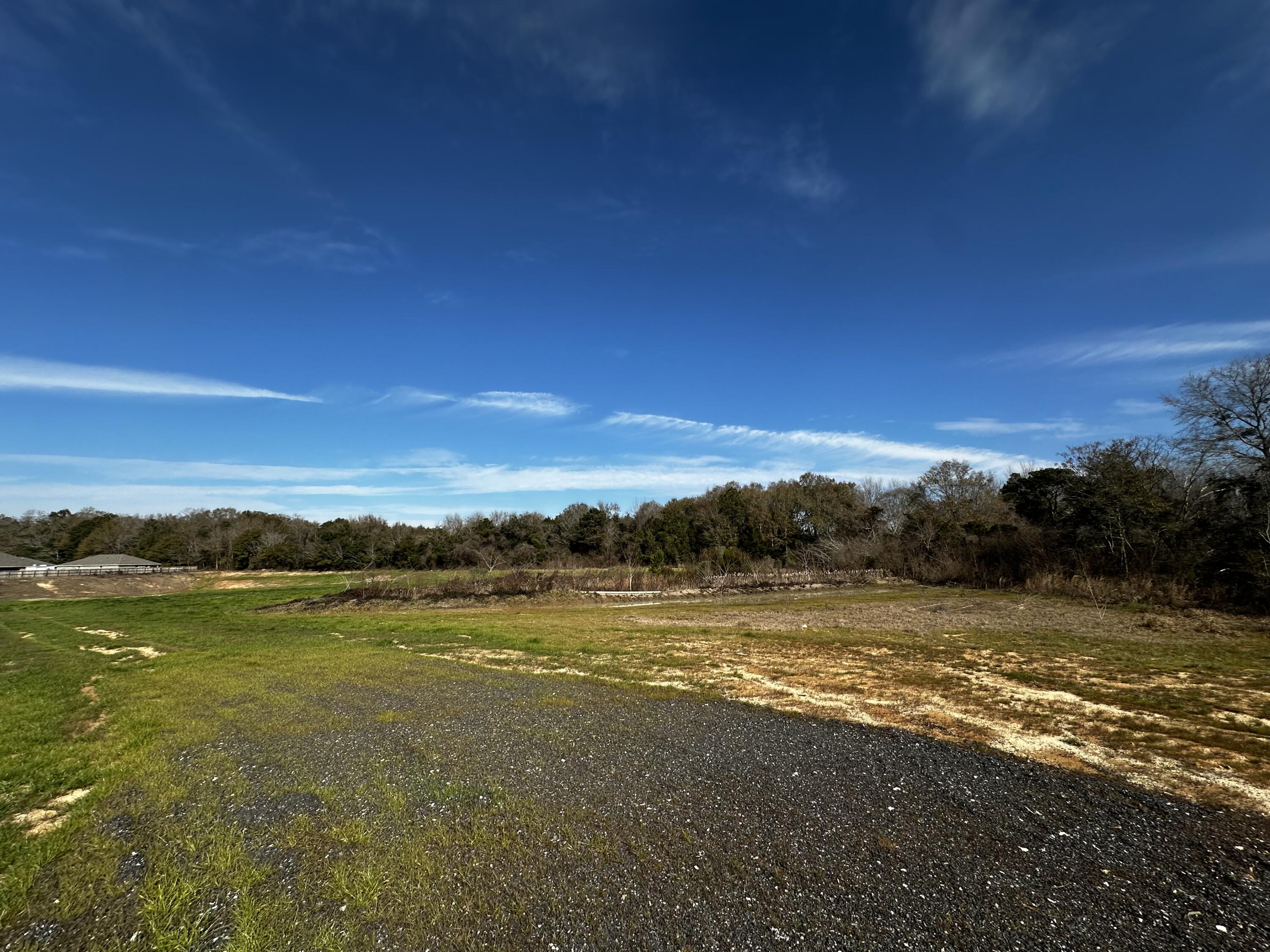 8.99 AC +/- Acres with paved road frontage on Charlie Day Road in Baker!  A level homesite area sits toward the front of the property, providing a ready starting point for future plans. The rear of the property features an existing dirt pit that could serve as a space for recreational use such as dirt bikes or an RC track. The new I-10 connector is currently under construction, and Hwy 90 is easily accessible, supporting regional travel access.