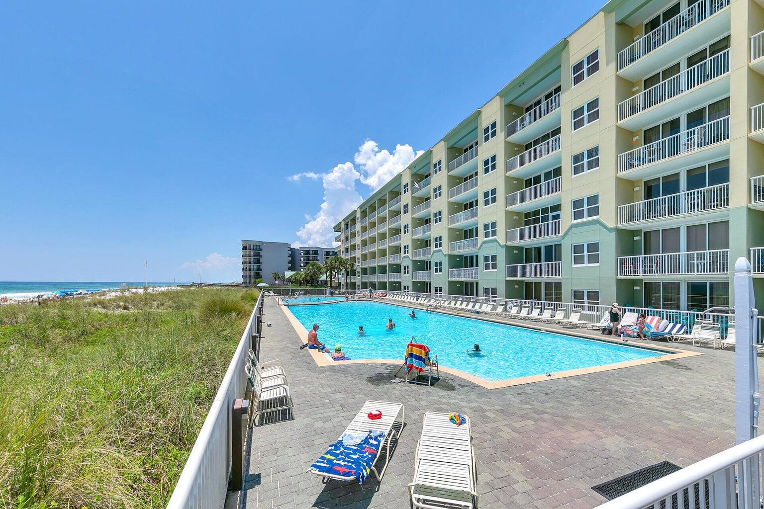 This lovely condo has a great view of the Gulf  and you get all the convenience of being on the first floor. No waiting for elevators, and easy access the to pool , grilling area, and the beach. 9' ceilings and floor to ceiling windows and sliding glass doors gives this property lots of natural light and an open feel. Open kitchen with granite counters and stainless appliances.  The double sized patio is great for relaxing and opens to landscaped green space. 2 Gulf front pools, 1 is seasonally heated. There is also a fitness room and covered parking. Many fun restaurants and attractions in the area.
