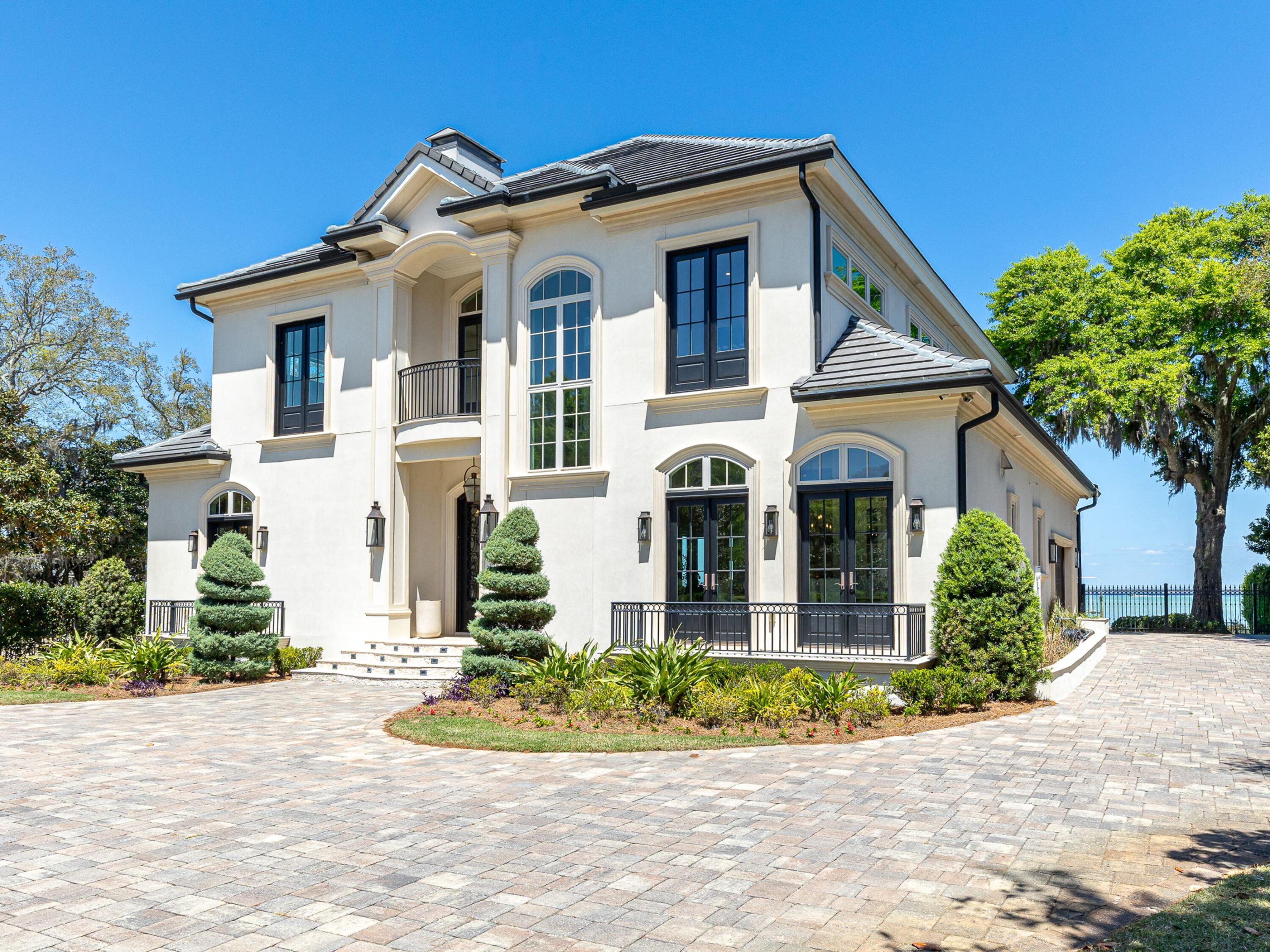 Set on a large, fenced and remarkably private bayfront lot, this five-bedroom residence captures the kind of waterfront living that rarely comes to market. With sweeping bay views from nearly every room, a substantial dock setup built for serious boating and a resort-style outdoor area designed for long afternoons and lively evenings alike, the property offers both presence and performance in equal measure.

Inside, the home feels open, bright and thoughtfully tailored throughout. Expansive windows pull the water into the living spaces, while travertine flooring, custom light fixtures, custom-made window treatments and finely crafted cabinetry, built-ins and woodwork add warmth and polish. The kitchen is generously scaled for entertaining with a massive breakfast bar, stainless steel appliances and exceptional cabinet storage. Just beyond, the main living area opens to the outdoor patio where the pool, spa, outdoor kitchen and fireplace create a natural extension of the home.

The primary suite is privately positioned on the main level and features bay views along with dual vanities, an oversized walk-in shower and a separate soaking tub. Upstairs, a sitting area opens to a balcony and leads to a flexible bunkroom or bedroom with wet bar, plus three additional guest bedrooms. One includes an attached bunkroom and full bath, while the others are arranged in a Jack-and-Jill configuration.

For boating enthusiasts, the waterfront improvements are a standout: a newer 50-foot dock with three boat slips, including one covered slip, two boat lifts sized for approximately 50-foot and 30-foot vessels, plus two personal watercraft lifts. A concrete seawall with limestone riprap adds another layer of peace of mind.

The home is equally impressive behind the scenes with a complete audio, video and lighting automation system, app-controlled lighting and TVs, indoor and outdoor audio, eight security cameras, Daikin VRV multi-split AC systems, large tankless water heaters with a continuous recirculating loop, four outdoor Big Ass Fans, gutters, a custom power gate, custom metal fencing and railings, plus extensive landscaping enhanced by dramatic night scaping.

Life here places you within easy reach of all that Destin is known for -- from its sugar-white beaches and clear emerald waters to world-class boating, fishing, and championship golf. Dining, shopping, and entertainment are equally abundant, with everything from waterfront restaurants and marinas to upscale retail and local favorites just a short drive away. This is a bayfront property that understands exactly what luxury on the water should look like.