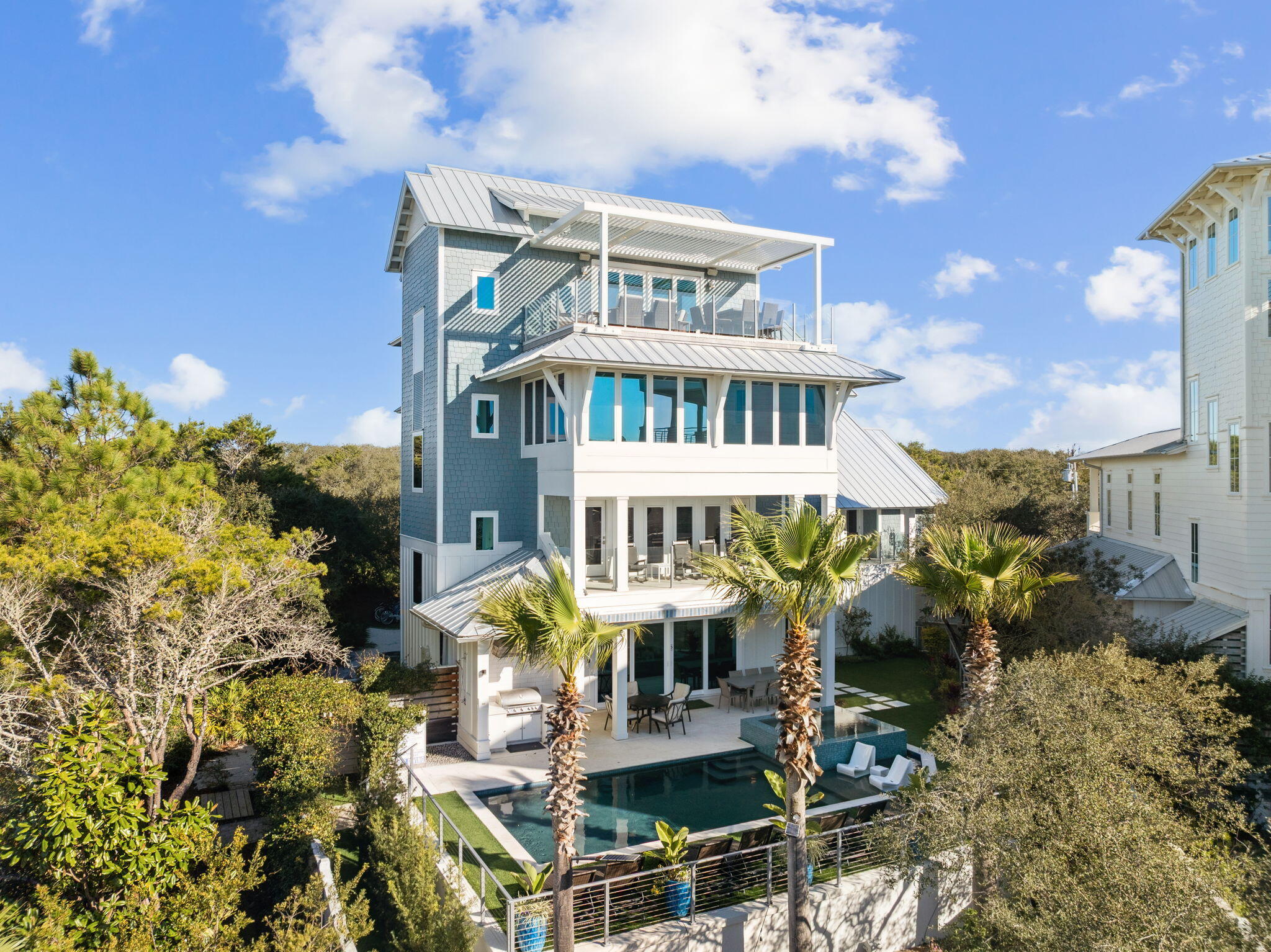 Welcome to 230 Blue Lake Road offering the ultimate in luxury coastal living positioned just steps from a deeded beach Access in Old Blue Mountain Beach. This new construction four-story residence seamlessly blends custom design with resort-style amenities, all serviced by a custom elevator that provides effortless access to every level of this exceptional home.

The first floor sets the tone for beach entertaining with a spacious den, formal dining room, and a chef's dream kitchen equipped with dual refrigerators, ranges, and dishwashers--perfect for accommodating large gatherings. The expansive living room features oversized sliding glass doors that open onto the infinity-edge hot tub and pool, creating a seamless indoor-outdoor flow that truly brings the beauty of coastal living inside. The pristine yard showcases immaculate green turf that maintains its lush, vibrant appearance year-round without the maintenance. Below the pool deck, discover the perfect beachside hangout with Adirondack seating, an outdoor ping pong table, and corn hole boards, all illuminated by charming café lights for evening enjoyment. In addition to the beach, the home's location offers convenient access to the 30-A bike path & paddling on Redfish Lake.

Ascend to the second floor where a generous living area opens to a private balcony offering Gulf views and overlooks of the sparkling pool below. The luxurious master suite features a private balcony, along with a luxury bathroom complete with a soaking tub and walk-in shower.

At the top of the stairs leading to the third floor, you will find a glass-enclosed fitness room with wrap-around windows that frame panoramic Gulf views, transforming every workout into an inspiring experience.

The fourth floor crowns this amazing home with a game room featuring a wet bar and pool table, opening onto a rooftop deck with spectacular Gulf views. Here, a gas fire pit creates the perfect gathering spot for sunset views over the emerald waters. With seven bedrooms each with its own en-suite bathroom and three bedrooms featuring custom built-in bunk beds, this home comfortably sleeps 26 guests, making it an exceptional short-term rental investment opportunity.

Modern conveniences include a motorized louvered pergola for the rooftop deck, which automatically closes when it senses rain, electric vehicle charging in the garage and a temperature-controlled pool that can be both heated and cooled for year-round comfort.

With its relaxed location nestled on a private wooded lot and convenient location to dining, shopping and outdoor activities, this home is perfectly suited as a primary or second home. Further, with its abundance of amenities, ample parking and close access to one of 30A's best beaches, it also presents an amazing investment opportunity.