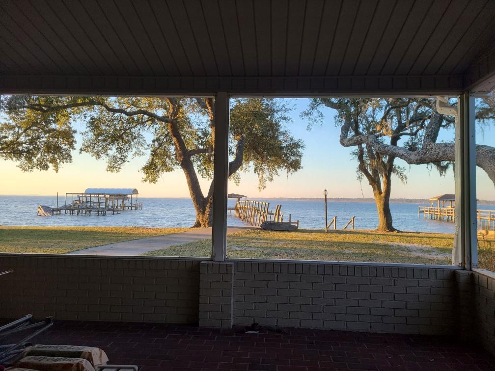 This amazing bay front open floor plan has paradise in the back yard. With a large screened in porch, fire pit, dock, boat ramp. Large oak and magnolia trees surround this .46 acre lot. Garage for 4 cars and a massive driveway for more cars. Have an RV? There is also space to park your RV right at your home.  Inside has a propane gas fireplace, granite countertops in the kitchen and lots of views from inside looking at the beauty out back. Plus so much more. For your private tour call today.