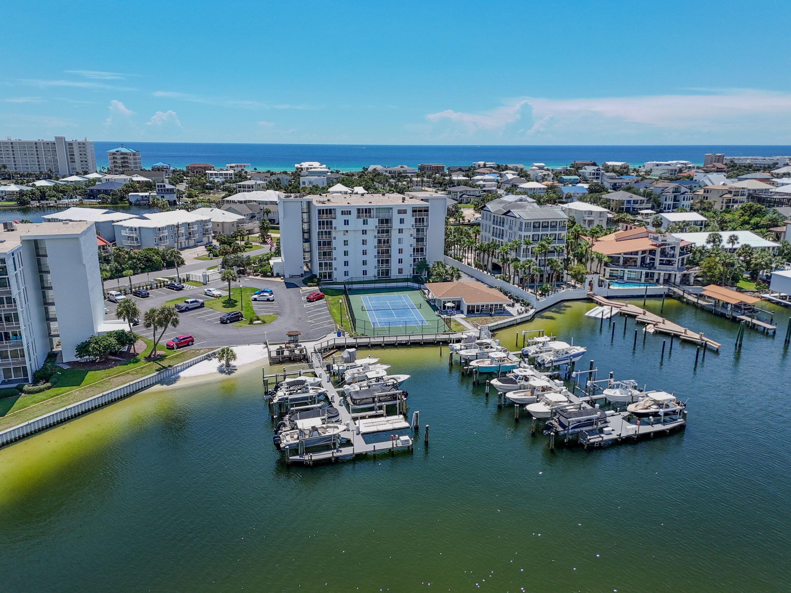 This amazing 2 bedroom and 2 bathroom fifth floor unit has amazing views.  The furnished condo offers beach and Holiday Isle views and located on the Destin Harbor.  The large, renovated kitchen is open to the living room and spacious balcony.  The unit has a large master suite facing out toward the gulf side and a renovated master bathroom with large tiled shower.  The additional bedroom has enough room for bunks or two beds for more rental numbers   This unit has been updated and the complex just completed and exterior renovation.    Dolphin Point has a beautiful pool, marina/docks on the Harbor and a deeded beach access.  The gated condo project offers access to everything you've been dreaming of.  Marina and boat slips for rent, tennis/pickleball courts, owners' storage, launch for kayaks/paddleboards, pool, grilling area and 24-hour security.  This Condo project and unit has everything!