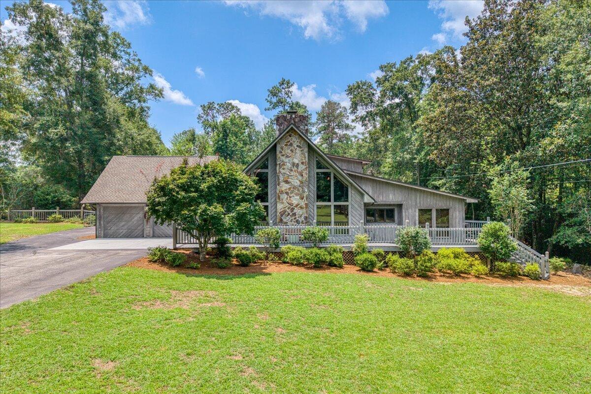 Nestled on nearly 3.5 acres in Jay, this custom-built home offers a peaceful setting with a creek bordering the property and a winding driveway leading to a private homesite. Lovingly cared for by its original owners, the 4-bedroom, 3.5-bath home has been updated with a 2023 roof, two HVAC systems replaced in 2020 and 2023, and a 2024 water heater and is being sold PARTIALLY FURNISHED. Inside, 20-foot cathedral ceilings with exposed cedar beams, floor-to-ceiling windows, hardwood flooring, porcelain tile and a striking stone fireplace with a Buck Stove insert create an impressive main living space. The kitchen features solid wood cabinetry, a center island with breakfast bar, and a pantry, while the adjoining family room includes a built-in entertainment center and direct access to the open deck for easy indoor-outdoor living. The primary suite overlooks the pool and includes a spacious walk-in closet and a unique ensuite bathroom with separate his-and-hers vanities connected by a dual-access pass-through shower. Two additional main-level bedrooms each offer walk-in closets. Upstairs, a loft overlooks the living area and leads to an oversized fourth bedroom featuring cathedral ceilings, attic storage, a large walk-in closet, and an updated bathroom with double vanities and a tiled walk-in shower. Step outside to enjoy the in-ground pool surrounded by composite decking, mature landscaping, and a covered gazebo with an attached storage closet for pool equipment. A dedicated poo l-access bathroom adds convenience for outdoor entertaining. The property also includes a two-car garage with two storage rooms, a one-car carport with attached storage, Vacuflo central vacuum, an Aquasana whole-house water filtration system, a security system, and an irrigation system supplied by a private well. With wooded privacy, open space, and room to expand, this property offers the flexibility to enjoy country living while still having every modern convenience.
