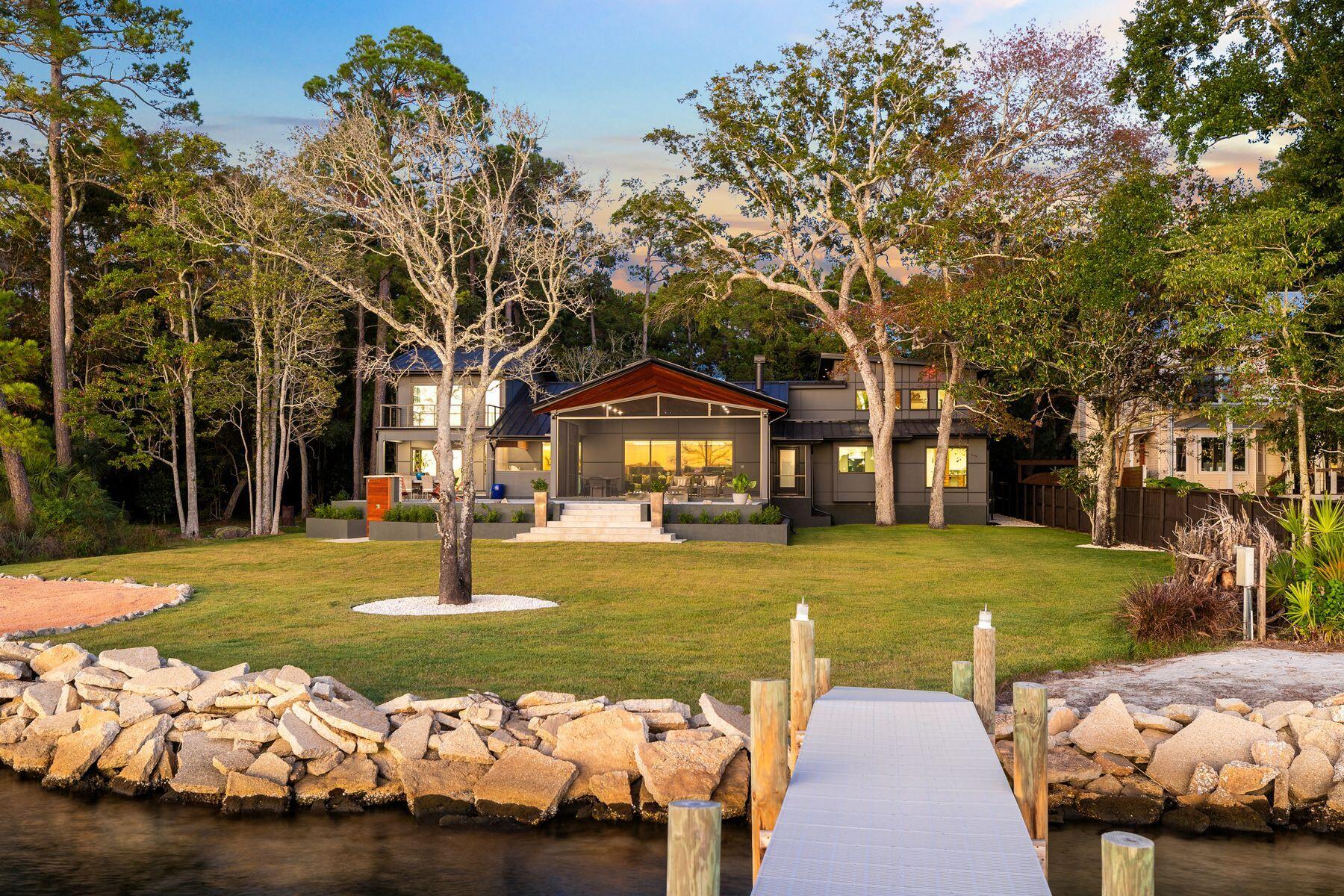 Tucked away on nearly an acre fronting Boggy Bayou, this architectural masterpiece embodies the perfect balance of luxury, tranquility, and thoughtful design. Completely reimagined and expanded in 2024 by SMP Architecture and brought to life by Hughes Construction Group, the residence blends a striking mix of concrete, Hardie board, Brazilian Cumaru wood, and stone for a sophisticated, modern exterior that harmonizes with its lush surroundings. Every element—from the hand-selected natural materials to the precision of the renovation—was chosen to create a serene, cohesive retreat that feels both artful and functional. Step through the custom pivoting solid wood door into a calm, open interior grounded in natural textures European oak floors, rectified porcelain tile, tumbled stone, sealed concrete, and custom walnut cabinetry. Frameless doors and hidden storage lend a seamless, minimalist flow, while statement features like the hand-poured 3D concrete fireplace and carved limestone sink from Spain showcase craftsmanship at every turn. The kitchen is both a chef's dream and a design showpiece, featuring quartzite and Dekton countertops with a custom sinker cypress table, an AGA 48" induction cooktop, Fisher & Paykel and Thermador appliances, and a concealed walk-in pantry with cooler drawers, wine storage and coffee nook. Just beyond, the living spaces open to a spacious screened lanai with a Brazilian Cumaru tongue-and-groove ceiling, outdoor kitchen and panoramic water views.

Located on the first level, the primary suite offers a spa-inspired escape, complete with a concrete soaking tub and multi-head custom shower, dual custom walnut vanities, a walk-in closet, water views and direct access to the waterfront porch. Two additional bedrooms with a shared full bathroom are conveniently located on the first floor. A second-story private guest suite offers a quiet haven with its own ensuite bath, walk-in closet and a private balcony overlooking the bay ideal for guests seeking solitude and water views. Across the home, an additional second-level features another guest suite with ensuite bath, plus a dedicated wellness retreat. This calming space includes a wet bar, massage table, cork flooring, a Sunlighten infrared sauna and plumbing for a future cold plunge, all oriented toward peaceful water vistas creating a spa-like sanctuary within the home. A dedicated gym space and laundry room lead to an oversized garage including an EV-ready 220 plug, built-in pressure washer for convenient vehicle washing and storage.

Outside, the property continues to impress with a Cumaru and stone shower, citrus trees, and a regulation-sized sand volleyball court. The 150' Thruflow dock features deep water access, jet ski lift, and power and water service ready for days spent boating to Destin Harbor, Crab Island, or the open Gulf, all just minutes away. Enjoy the best of both worlds peaceful waterfront living in the heart of Niceville, with the dining, shopping, and white-sand beaches of Destin just across the bay. Every detail of 1435 Bayshore Drive was designed for comfort, longevity, and the effortless enjoyment of coastal living.