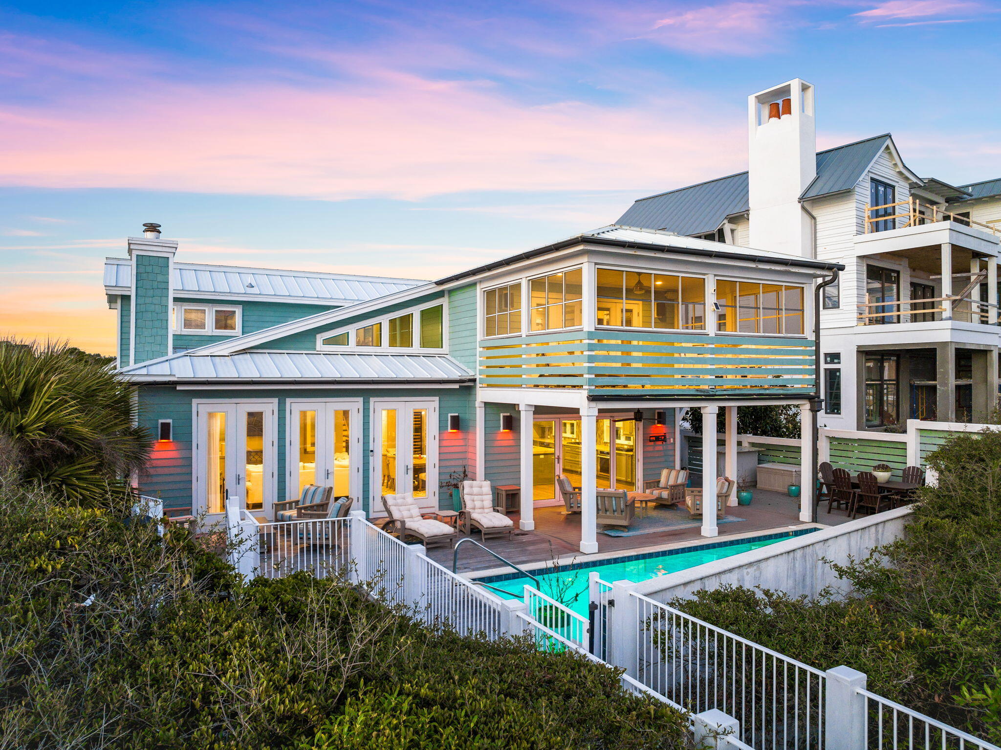 Set within the gated enclave of Camp Creek Lake in Inlet Beach, 211 Pelican Circle offers something increasingly rare along 30A; 76 feet of private Gulf frontage paired with a thoughtfully reimagined interior by acclaimed architect Geoff Chick. This three-story residence spans over 4,000 square feet across four bedrooms, a loft, and a media room, with the flexibility to restore a fifth bedroom should the next owner choose.

The home was designed to dissolve the boundary between inside and out. A NanaWall glass system opens the main living area directly to a heated saltwater pool cradled within the dunes, surrounded by multiple outdoor lounging areas - including a dedicated sunset-watching terrace that earns its name every evening. The summer kitchen is outfitted for serious entertaining, with an Alfresco 42-inch rotisserie grill and a Coyote Asada Egg anchoring the space.

Inside, the chef's kitchen delivers a Wolf gas cooktop, dual Thermador ovens, and a built-in coffee maker among its appointments. A wood-burning fireplace anchors the main living room, while the media room on the second level offers its own wet bar and fireplace for a more intimate retreat. The primary suite crowns the third floor with sweeping Gulf views and a private balcony; a second en suite bedroom on the middle level provides its own quiet remove. A loft adjacent to the primary serves equally well as a reading room, home office, or bunk space. The lower level rounds out the home with a flexible entertainment area and two additional bedrooms with adaptable sleeping arrangements.

Practical luxury runs throughout: a whole-home generator, reverse osmosis water softener, and an elevator serving all three floors ensure comfort without compromise. Attached garage and enclosed golf cart storage complete the picture.

All information and dimensions to be verified by the Buyer.