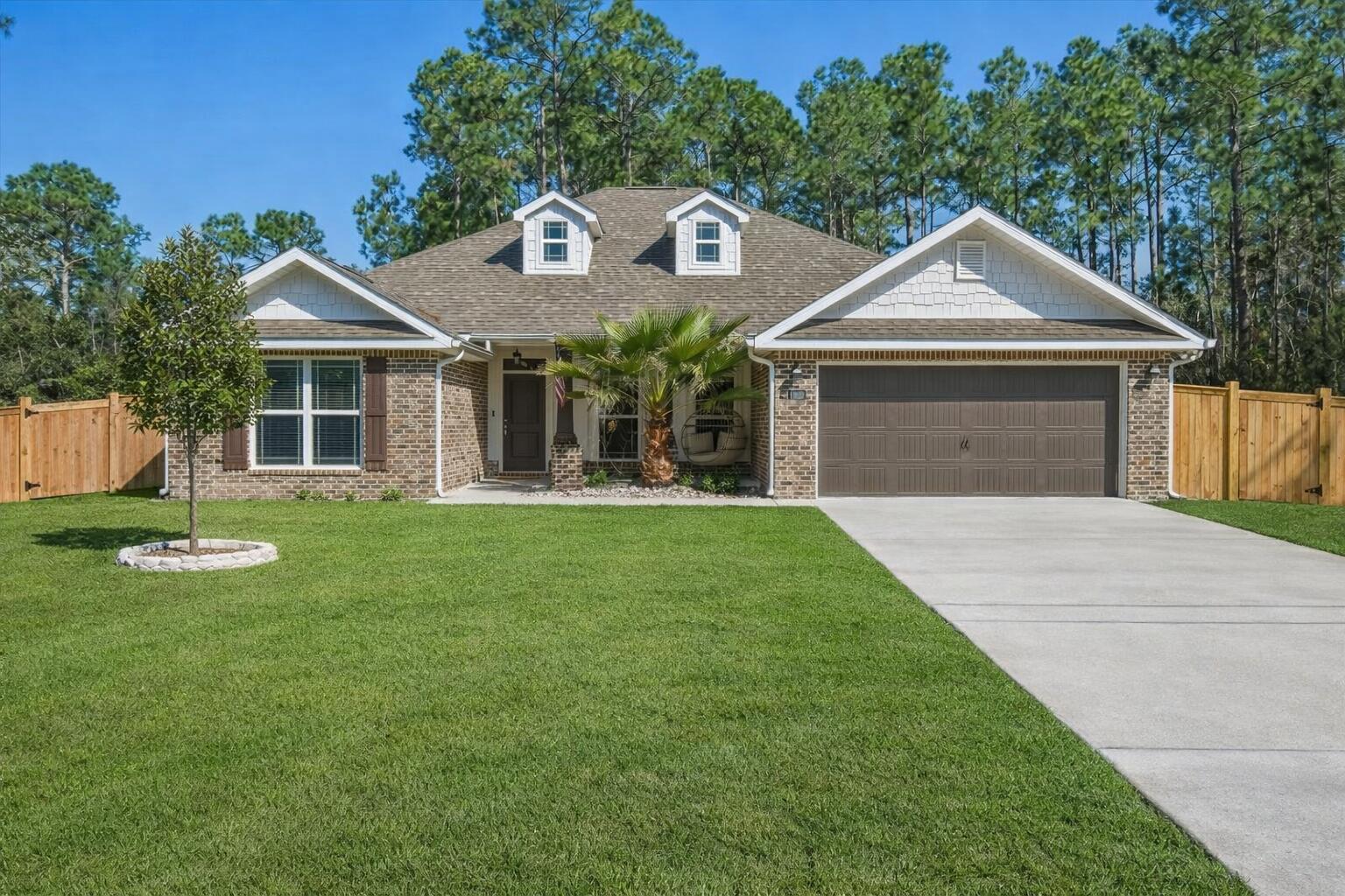Welcome to this beautiful 4-bedroom, 2-bath home offering 2,008 square feet of living space in the desirable Navarre, Florida area just minutes from the beach and many popular local attractions. Seller offering $5,000 toward new carpet, upgrades, or closing costs, offering flexibility to personalize the home to your needs. With great curb appeal featuring a brick exterior, bay windows, and a two-car garage, this home makes a wonderful first impression. Step inside to a bright and inviting open-concept layout that seamlessly connects the dining, living, and kitchen areas. Large rear windows fill the space with light and overlook the private, fully fenced backyard. The spacious kitchen features a large granite island with seating, stainless steel appliances, pendant lighting, and more. eat-in breakfast area and a separate dining space. The primary suite offers a relaxing retreat with a tray ceiling, ceiling fan, and windows overlooking the backyard. The ensuite bathroom includes dual vanities, a custom-tiled walk-in shower with glass door, a separate soaking tub, and a large walk-in closet. Secondary bedrooms are generously sized and provide plenty of closet space. The additional bathroom features granite countertops and a spacious layout. A well-appointed laundry room includes extra storage space for added convenience. Step outside to enjoy the fully fenced backyard complete with a covered patio for grilling and entertaining, as well as a cozy fire pit area perfect for relaxing evenings. Located near top-rated schools, beautiful Gulf Coast beaches, and the best that Navarre has to offer, this home provides the perfect blend of comfort, convenience, and coastal living. Schedule your showing today and come experience the Florida lifestyle!