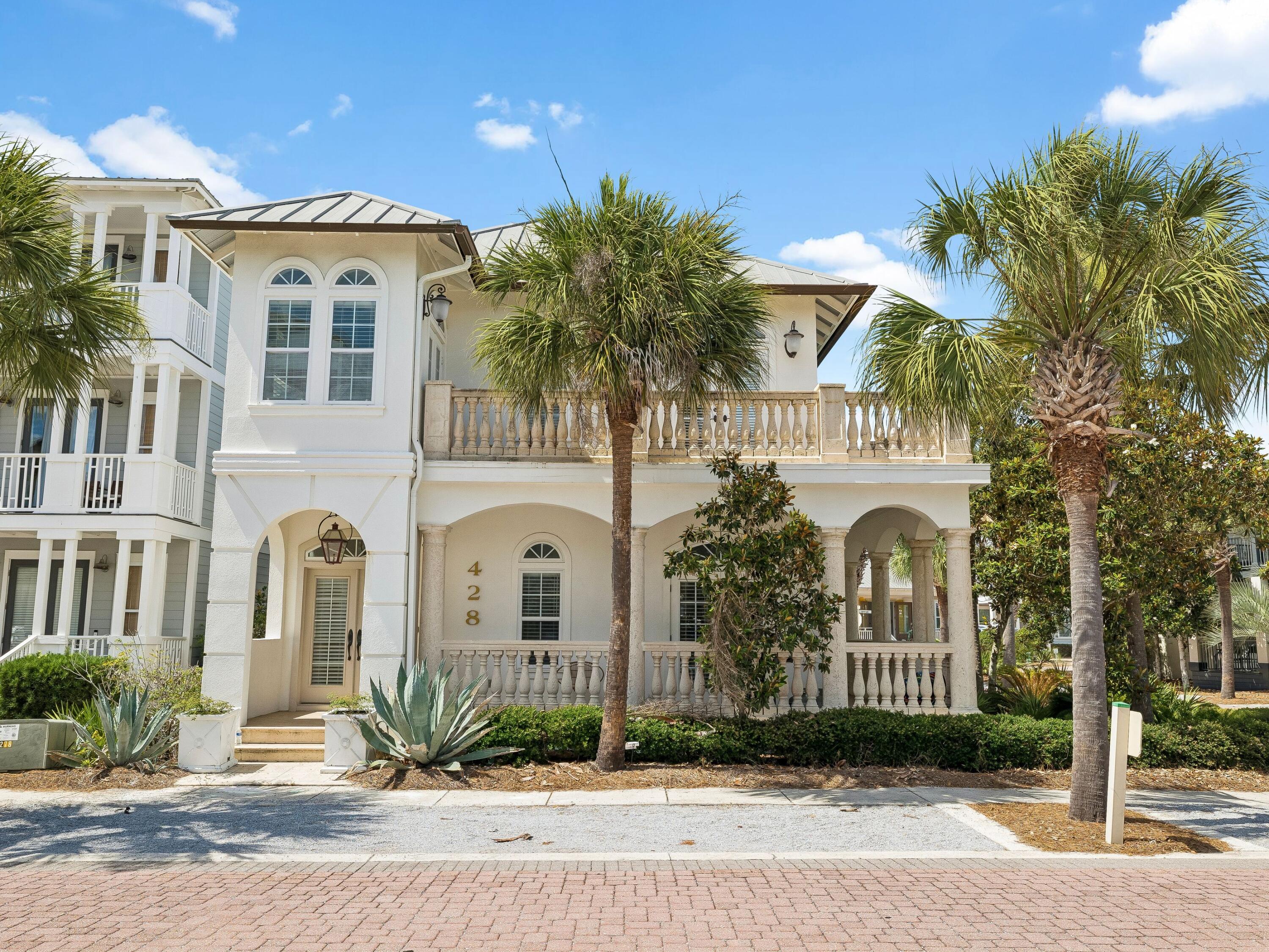 A stately coastal retreat where timeless Mediterranean elegance meets effortless beachside living in the heart of Seacrest Beach. Offering four bedrooms and four baths across two gracious stories, this residence is wrapped in soft white stucco beneath a standing-seam metal roof, captivating from the curb with its arched colonnade, hand-finished stone balustrades, and a canopy of swaying palms. Step inside to sun-filled living spaces defined by soaring ceilings, arched transom windows, and warm hardwood floors. At the heart of the home, a gourmet kitchen dazzles with crisp white cabinetry and a shimmering crystal chandelier. A coveted main-floor primary suite offers single-level convenience and privacy, complete with a spa-inspired bath. Three additional well-appointed bedrooms offer serene retreats, while four spa-inspired baths showcase marble vanities, deep soaking tubs, and refined designer fixtures. An additional flex space, thoughtfully configured as a sleeping room, enhances the home's accommodation capacity and is currently utilized as a fifth sleeping area for rental purposes. Tiled balconies and a gracious covered loggia blur the line between indoors and out -- perfect for morning coffee or sunset gatherings.

A proven income producer, this residence grossed $141,000 in rental revenue in 2025 and is projected to reach $162,000 this year -- a testament to its enduring appeal and strong earning potential. Beyond the residence itself, the generously proportioned homesite presents a rare opportunity for future enhancement, with space suitable for a private pool, carriage house, or both, subject to applicable approvals.

Set within one of 30A's most coveted communities, Seacrest Beach offers an unrivaled resort lifestyle anchored by its legendary 12,000-square-foot lagoon pool -- one of the largest in Florida -- complete with cascading waterfalls, a fountain, children's splash area, and poolside snack bar. Residents enjoy seasonal tram service to the sugar-white sand, deeded beach access, more than a mile of shaded walking trails, and a grassy amphitheater hosting concerts and festivals year-round. Just minutes from the boutiques and dining of Rosemary Beach and Alys Beach, 428 Beach Bike Way is a rare harmony of sophistication, comfort, and coastal charm -- Emerald Coast living at its very finest.