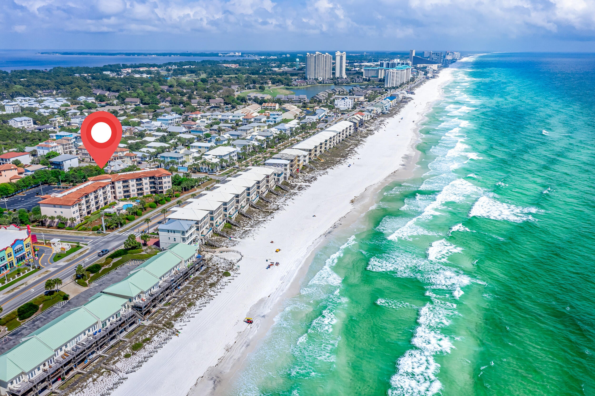 Unit 107 Emerald Waters is located on Scenic Gulf Dr in the Frangista Beach area of Miramar Beach. This 2BR, 2BA is conveniently located on the first-floor -- meaning no need to ever wait on elevators. Park near your unit and enjoy easy access from the condominium to the open balcony.

The kitchen features granite countertops, custom tile-backsplash, under-cabinet lighting, stainless steel appliances, and pendant lights over the breakfast bar. 
The primary suite includes an updated bathroom with a tiled walk-in shower and double-sink vanity.
Notable details include 9-foot ceilings, crown molding, updated lighting & plumbing fixtures, tile plank flooring throughout the main living areas and both bedrooms, and a brand-new HVAC system. The laundry room is equipped with a FULL-SIZED washer and dryer. 

The guest bedroom is designed for maximum versatility, featuring shiplap accent walls and custom built-in twin-over-king bunks that provide additional sleeping space without sacrificing comfort. The adjoining guest bath offers a tub/shower combo, tile surrounded with a sliding glass enclosure.
Step outside to a covered porch and grassy area, perfect for enjoying the gulf breeze or providing convenient outdoor space for pets. Emerald Waters is a low-density, 36-unit complex with a pool, hot tub, grilling area, ample parking, and professionally maintained grounds. 
 The seller anticipates $33K in gross rental revenue for 2026.
The community improvements that have already been completed and funded, including a new roof, structural columns, exterior re-painting, and updated exterior lighting. 
Scenic Gulf Drive is a top southwest Walton County destination. Emerald Waters is convenient to the beach, restaurants, a coffeehouse with Wi-Fi, and a short drive to Miramar Beach destinations. This turnkey condo offers an exceptional combination of location, convenience, and revenue stream potential.