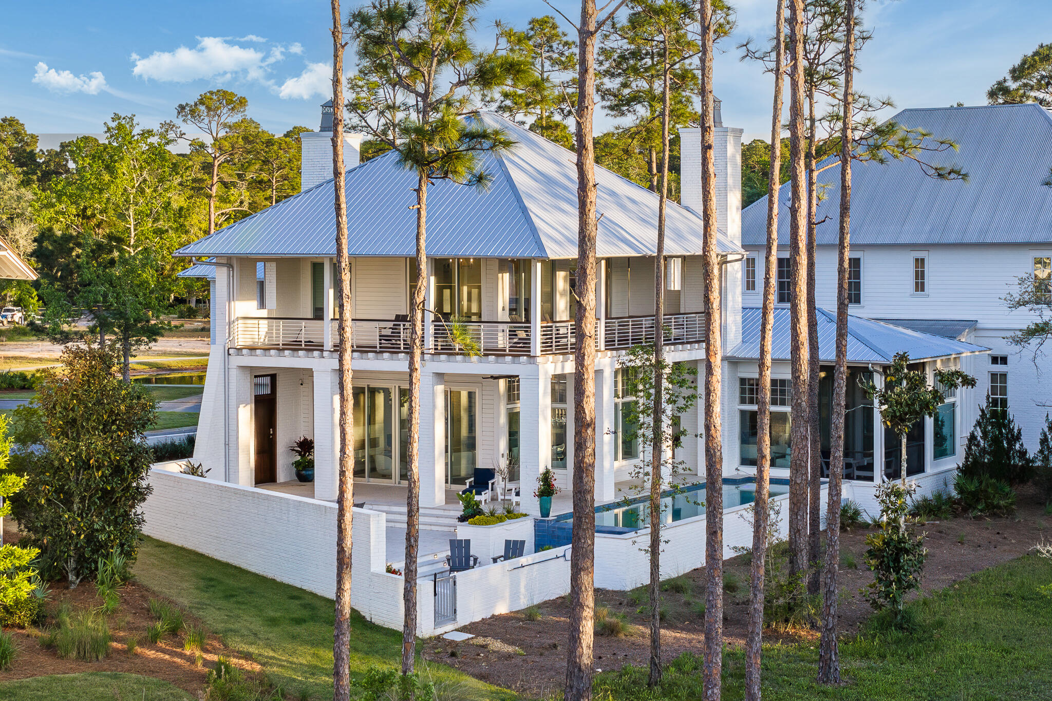 Located in the prestigious gated waterfront community of Churchill Oaks, this amazing contemporary home offers 4 bedrooms and 4.5 bathrooms plus a custom bunk room.  Positioned to capture the expansive bay views and backing to a conservation preserve, the property provides exceptional privacy.  Features include two primary suites, three laundry rooms, ceramic tile flooring, a walk-in climate controlled wine room and a steam shower.  The chef's kitchen is equipped with premium Miele appliances, custom cabinetry and designer lighting.  Outdoor living includes a negative edge pool and fire pit, ideal for enjoying the waterfront setting.  The property also includes a 50 FOOT BOAT SLIP making it ideal for boating enthusiasts. A beautifully designed carriage house above the garage, is complete with a private entrance for added flexibility and privacy.  Connected to the main residence by a charming breezeway, the space is ideal for guests and extended family. The carriage house features a mini kitchen, and it's own washer and dryer, creating a functional and comfortable separate living area.  Churchill Oaks includes an expansive bayfront clubhouse, marina and walking paths.