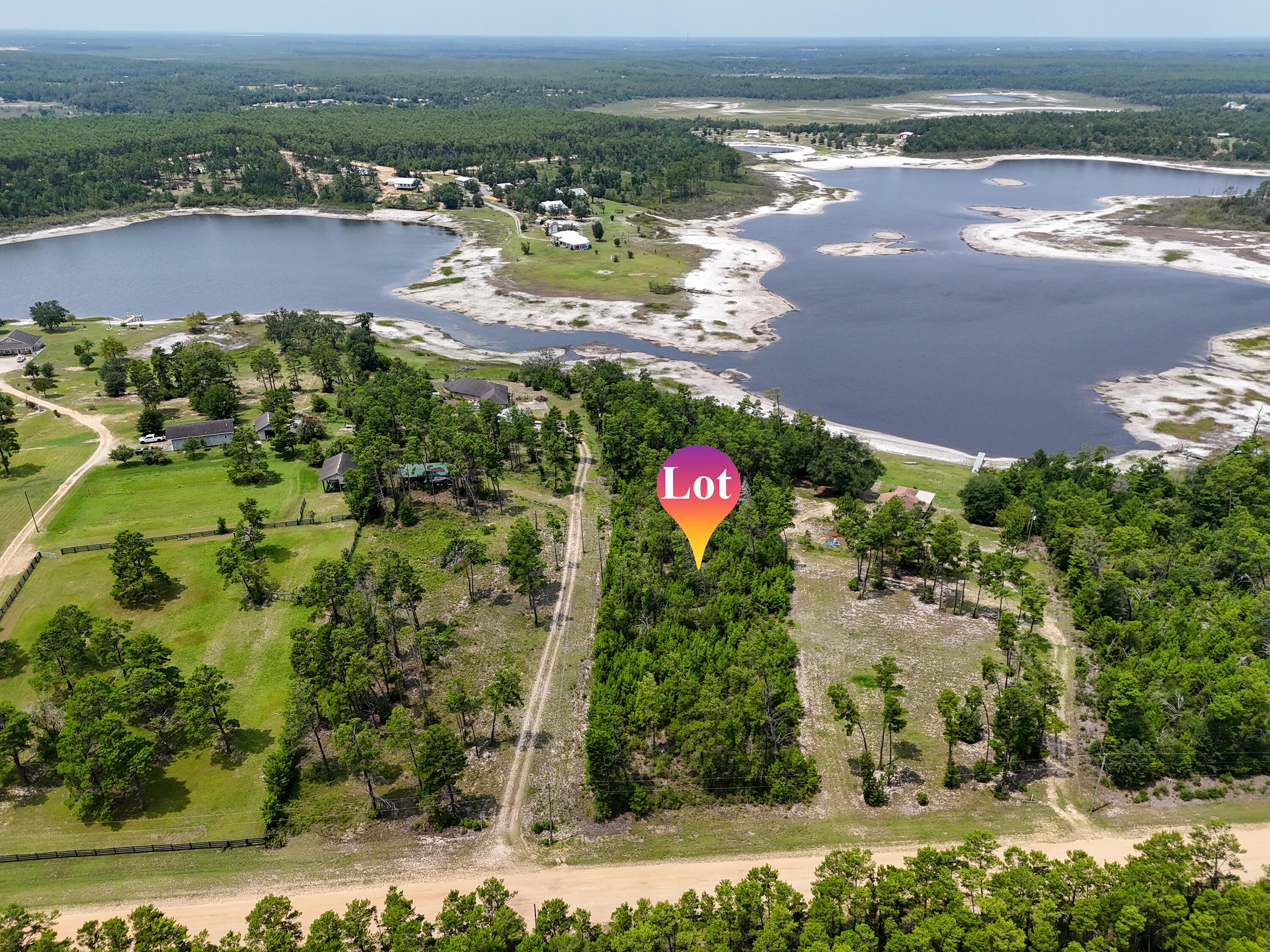 Escape to a quiet and peaceful retreat in the gated community of Long Lake Estates. This is a rare opportunity to own premium lakefront acreage in one of the area's most scenic and private settings. Lot 12 offers 5.26 acres with approximately 283 feet of frontage on beautiful Long Lake, providing the perfect backdrop for your dream home, weekend getaway, or future investment. Enjoy the freedom to build at your own pace with no build-out time requirements and minimal building restrictions. Whether you envision a custom lakefront estate, cozy second home, or private retreat, this property offers endless possibilities. Long Lake is exclusive to the community and known for its clear, refreshing waters. Spend your days swimming, boating, fishing, kayaking, paddleboarding, or simply relaxing by the lake from the privacy of your own backyard. The natural beauty, abundant wildlife, and peaceful surroundings create an unmatched lakeside lifestyle. Conveniently located just 35 minutes north of Panama City Beach in the peaceful Greenhead area, this property offers easy access from Highway 77 and is situated near the community's gated entrance. Combining privacy, recreation, and convenience, this exceptional lakefront homesite is a rare find. Don't miss your chance to own a slice of Florida lakeside paradise.