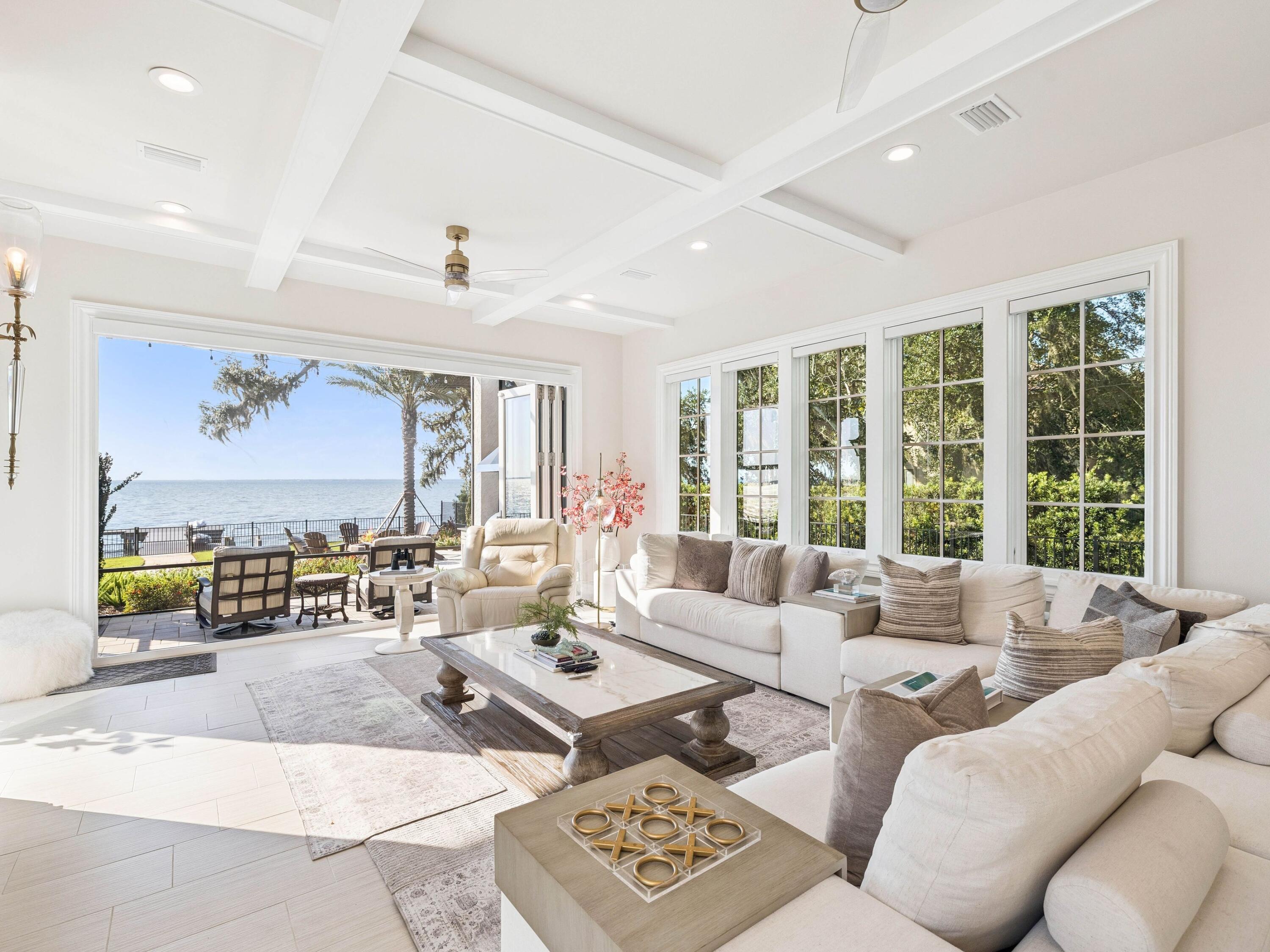 Set at the end of a quiet cul-de-sac, a private gated entry leads to an expansive motor court and air-conditioned garage with epoxy floors, extra parking, and golf cart space. Inside, soaring light-filled spaces unfold beneath a chandelier that rises by lift for easy care. Chevron-patterned wood floors, John Richard sconces, and interiors curated by Design and Dwell Homes set a tone of timeless luxury. The Grand Salon flows to a refined sitting room, which doubles as a music room, highlighted by a coffered ceiling.  A formal dining room showcases a 22-foot Venetian-plastered fireplace crafted by an artisan trained in Italy, flanked by marble arches and lit by a glittering chandelier.

Accordion doors open to the family room and second kitchen with beverage cooler, oversized Wolf range with hibachi-style cooktop, and folding glass doors to the terrace. Outdoor living is effortless with a barbecue station finished in Dekton, a fire pit, new landscaping and pavers, and a boardwalk leading through the fenced yard to the private dock. Step outside onto a screened terrace with ample space for dining and entertaining around the attractive pool and bubbling spa.

The chef's kitchen boasts Cambria Inverness Frost quartz counters, a Thermador wine refrigerator, Wolf appliances, dual dishwashers, and Bianco Dolomite marble accents. 

The primary suite offers bespoke his-and-hers closets, fireplace, fitness room, and a temperature-controlled wine room.  The spa-inspired bath pampers with steam shower, freestanding tub, sparkling chandelier, and under-counter refrigerator. Upstairs, this magnificent home showcases three stunning guest bedrooms, all accessed from the galleried landing. The huge family suite has twin bunks over a king bed and a kitchenette outfitted for guests to help themselves to morning coffee or late-night snacks. Rounding out the host of amenities, there's a dedicated movie theater with eight tiered leather recliners for watching your favorite films. The adjoining quartz-topped bar has twin beverage refrigerators for serving endless wine, soda and snacks. 

Additional highlights include a pool bath, a European lift, and a fenced dog run. The Village of Baytowne Wharf and Grand Boulevard put shopping, sports, and world-class dining within easy reach by golf cart. The resort also offers a private beach club, four championship golf courses, a world-class tennis center, and a deepwater marina, providing a lifestyle that truly has it all.