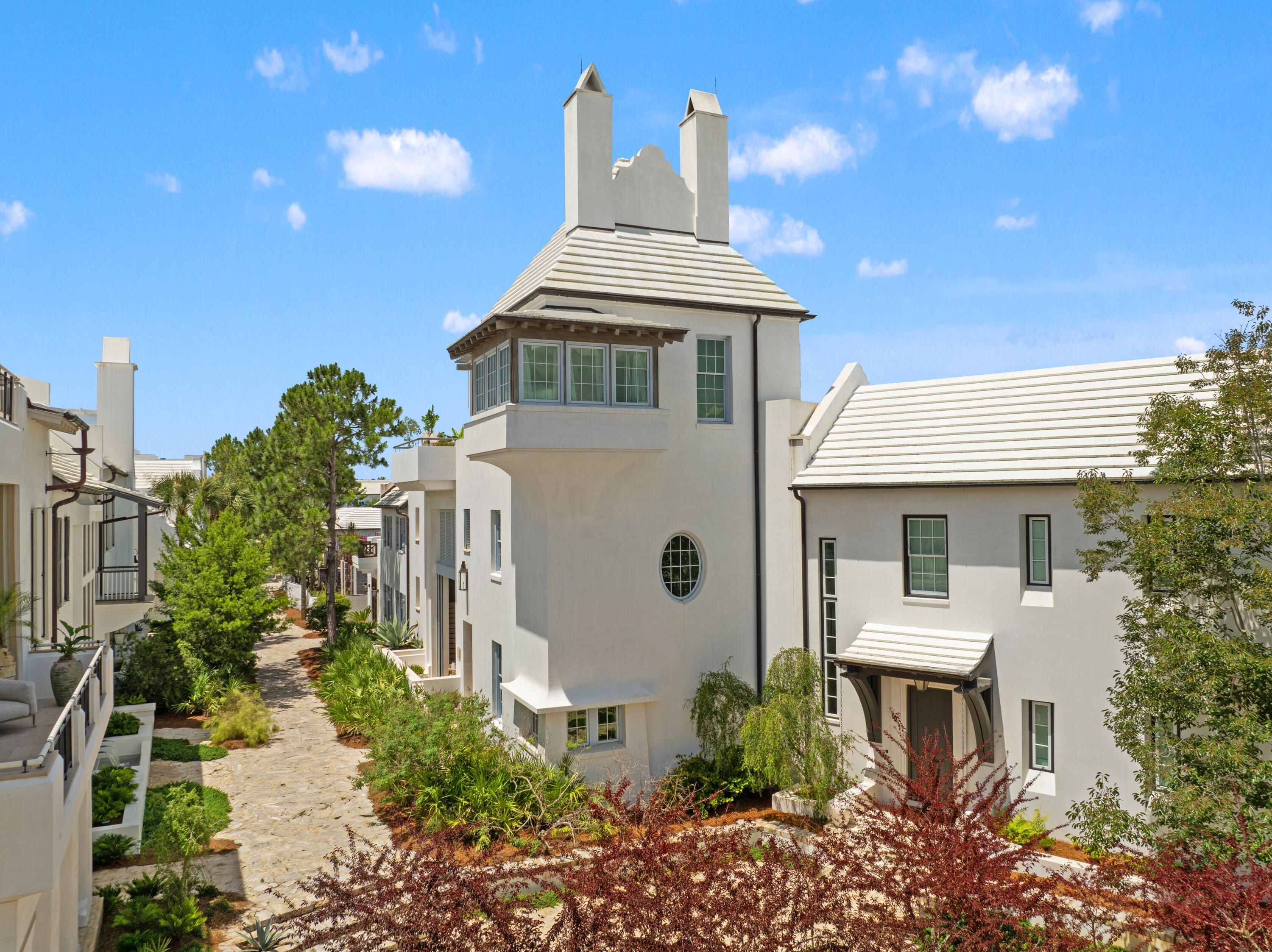 Welcome to 52 Butterwood Alley, an architectural masterpiece designed by renowned architect Gary Justiss, embodying the essence of Bermuda and Guatemalan courtyard living. This iconic 4,975 square foot residence is nestled at the southern end of Lake Marilyn, offering breathtaking views of the neighborhood's distinguished architecture, scenic rooftops, and the tranquil backdrop of protected nature preserves.

As you approach this stunning 4 bedroom plus bunk home, you are greeted by masterfully crafted woodwork by EF San Juan, featuring wormy oak accents that create a unique and inviting atmosphere. The home's third-story tower room provides an elevated vantage point for entertaining, practicing yoga, or simply enjoying serene evenings by the fireplace. The seamless transition to the outdoor roof terrace invites you to stargaze in the comfort of your own haven.

Access the property via the famed Seagarden walk pedestrian path, where monumental louvered sliding doors lead into the private courtyard. This outdoor oasis features a summer kitchen, pizza oven, dining banquet, and a refreshing swimming pool - perfect for gatherings and relaxation.

Stepping inside, the first level showcases cascading walls of Venetian plaster throughout the kitchen, dining, living areas, and the primary suite. The primary suite is a luxurious retreat, adorned with wormy oak details and a grotto niche bathtub lined with lava tile. Nestled between the courtyard and a separate private courtyard with its own fireplace, this suite allows for an abundance of natural light and gentle breezes when the sliding doors are open.

The gourmet kitchen is a culinary delight, featuring top-of-the-line Subzero appliances and a well-appointed scullery with a secondary refrigerator. Its thoughtful design fosters connectivity with the dining and living rooms, ensuring a welcoming space for guests.

Ascending to the second floor, you'll discover a cozy common area, complete with built-in shelves and a charming nook with wormy oak ceiling ideal for leisurely naps or quiet reading. This level also hosts three guest suites, including a detached casita for special visitors, a bunk room, and a versatile multipurpose room perfect for movie nights or creative endeavors. Each guest room can be accessed through the main home or via an external staircase, providing convenience and privacy.

Finally, guests are invited to the third level, where the home's iconic tower awaits. This unmatched space features Venetian plaster, a two-way fireplace, and vaulted wormy oak ceilings. Slider doors open to the expansive roof terrace, creating the ultimate interactive entertainment venue.

Don't miss the opportunity to own this exquisite property that harmonizes luxury, comfort, and nature in the heart of Alys Beach.  Schedule your private tour today!