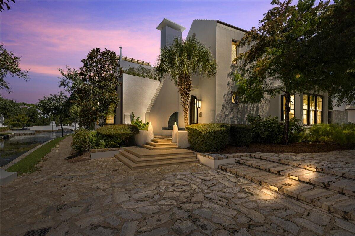 Rarely does a property of this scale become available in Alys Beach. 75 Hogpenny Aly presents a rare opportunity to own a true resort within a resort -- a 5,616-square-foot compound on an estate-sized corner lot overlooking Lake Marilyn. Designed by renowned architect Gary Justiss, with courtyard design by Khoury Vogt Architects, this is one of the largest homes ever offered in Alys Beach.

The residence is situated into four distinct, self-contained living zones.. The warm and intimate primary suite occupies its own 1st floor, adorned with custom floor to ceiling closets and a private patio. From the primary a set of stairs lead you to the wellness studio above. The central living wing features formal living and dining, a beautifully appointed kitchen, wine cellar, recreational room, cocktail bar, and private courtyard access. A separate guest structure provides two stacked suites, while the family wing includes bunk accommodations and ensuite baths -- totaling 7 bedrooms, 5 full and 2 half baths, sleeping up to 20.

At the heart of the compound is a private courtyard with heated pool, citrus grove, grilling area and puppy wash station. Enjoy sunsets from the 3rd-floor rooftop terrace with fire pit and wet bar overlooking the lake and community. Two media rooms, heated floors throughout, natural gas, and an oversized two-car garage complete the offering.

Set on Lake Marilyn, easy access to Caliza pool, the private beach and the exclusive Alys Beach Club Alys Beach amenities include deeded beach access, tennis, fitness, a community room, and full-time security. Also enjoy being close to the Caliza Pool, The Citizen, and 30Avenue.